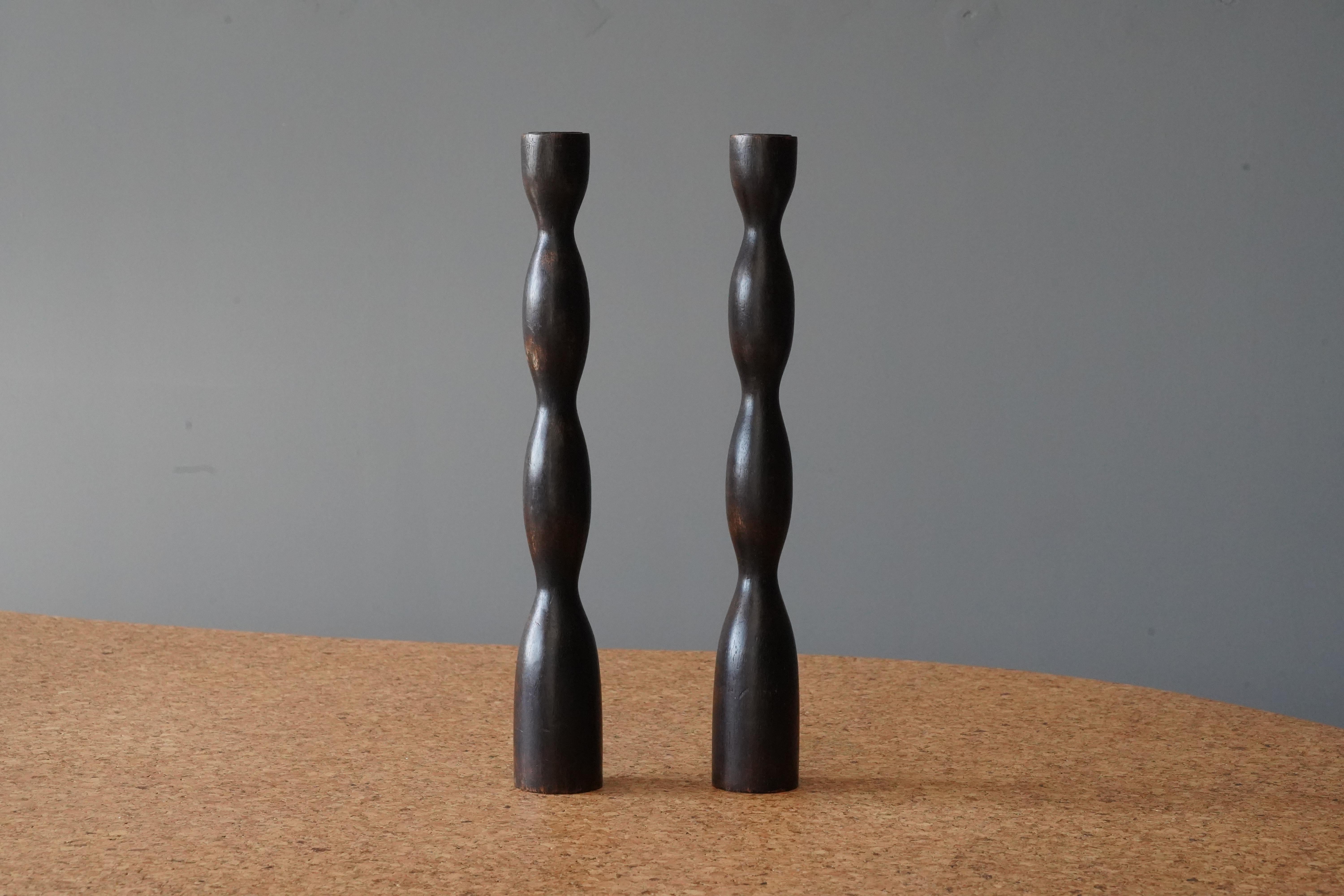 A pair of candlesticks. Produced in turned solid dark-stained wood. Unmarked.


    