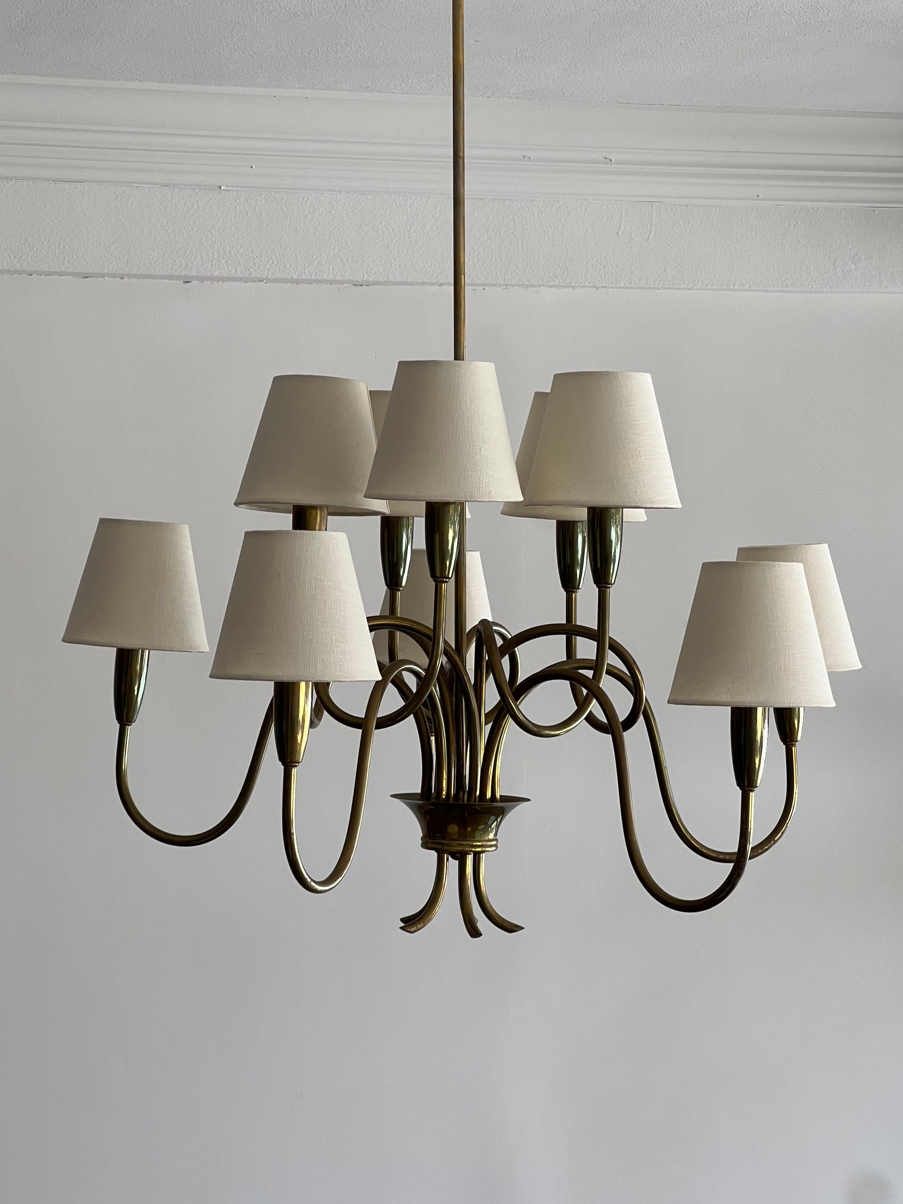 A chandelier light designed and produced in Sweden, 1940s. Features ten organically shaped arms, each mounted with a brand new lampshade.