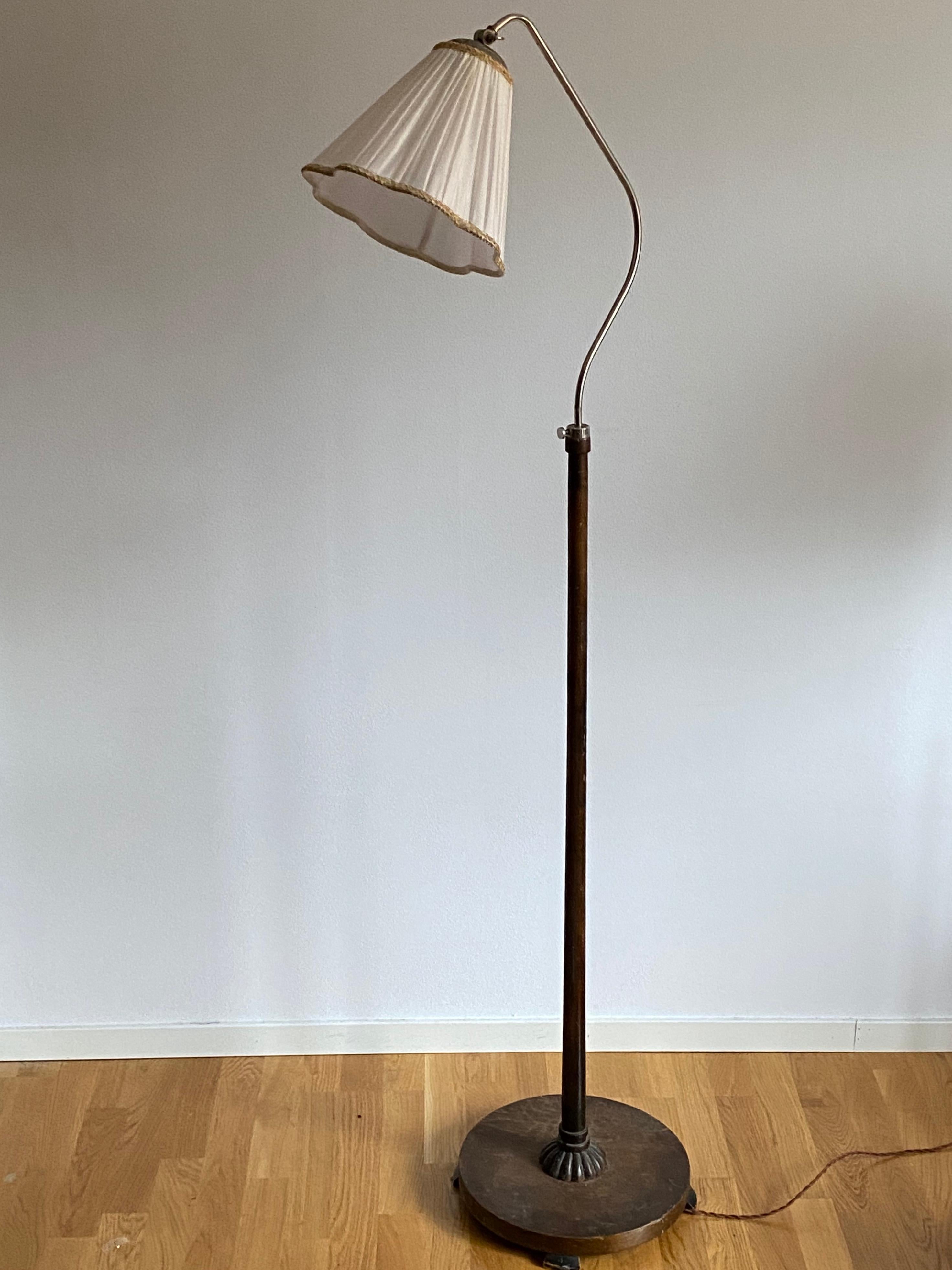 An adjustable functionalist floor lamp. With an adjustable arm. Brand new Swedish made lampshade. Chorme steel and dark-stained wood, features fine ornamentation to base.

Dimensions variable. 

Other designers of the period include Josef Frank,