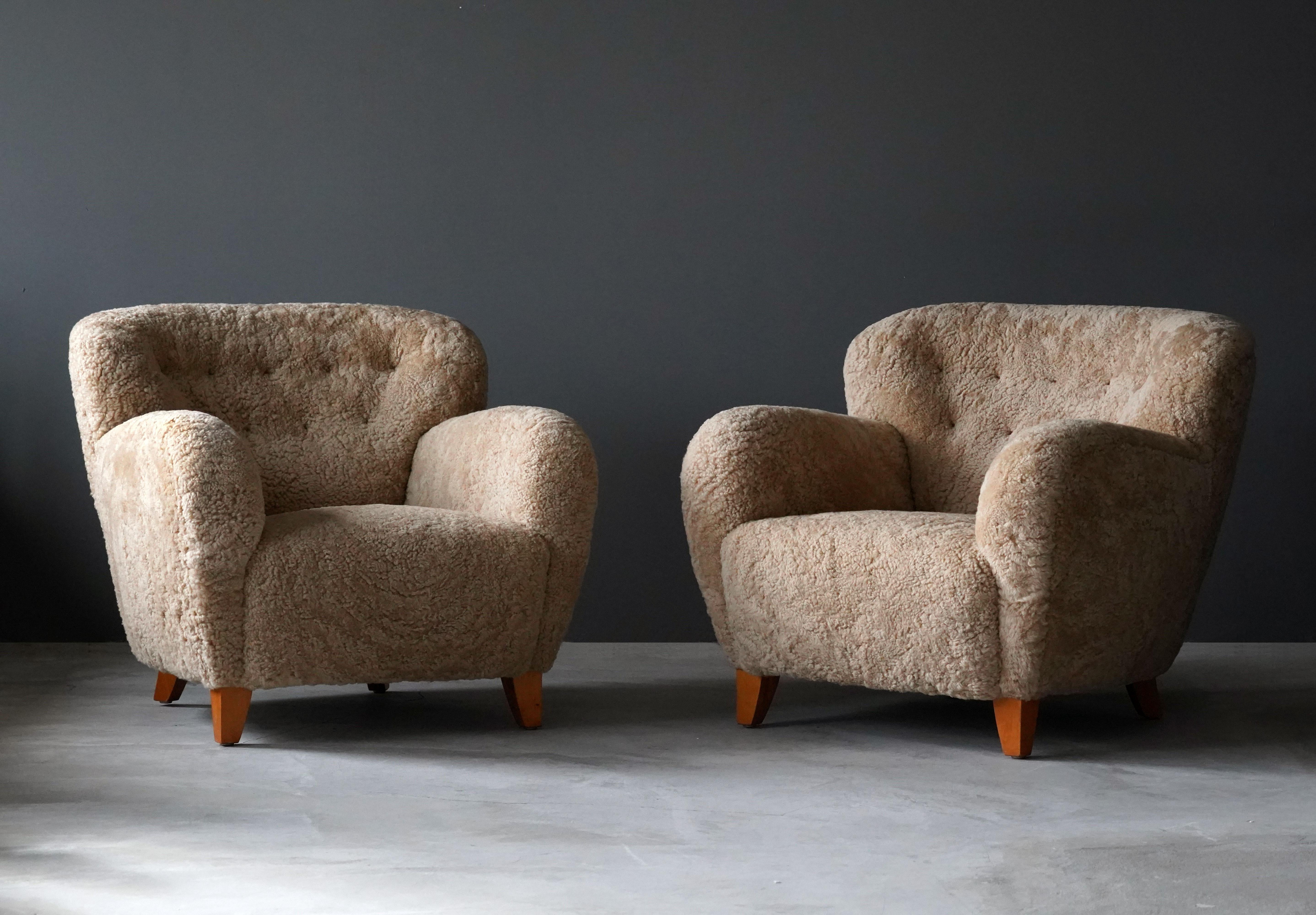 A pair of organic modernist lounge chairs. Designed and produced in Sweden, 1940s. Reupholstered in brand new authentic shearling upholstery. 

Similar in style to works by designers such as Flemming Lassen, Gio Ponti, Vladimir Kagan, Philip