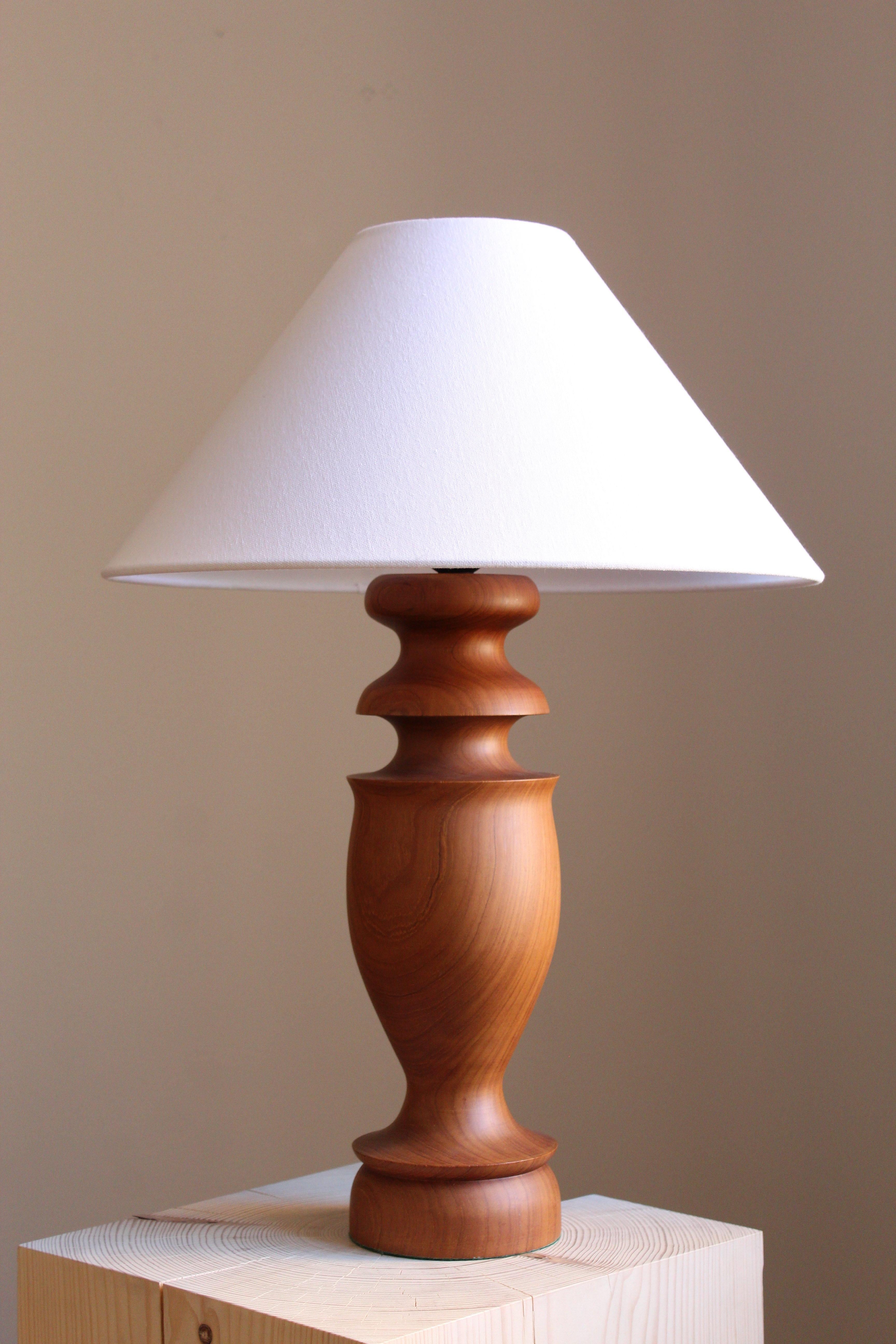 A sizable table lamp. Designed and produced in Sweden, 1960s. In finely turned solid teak. Lamp shade not included.