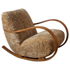 Designer suédois:: fauteuil à bascule organique en peau de mouton en bois teinté:: Suède années 1940