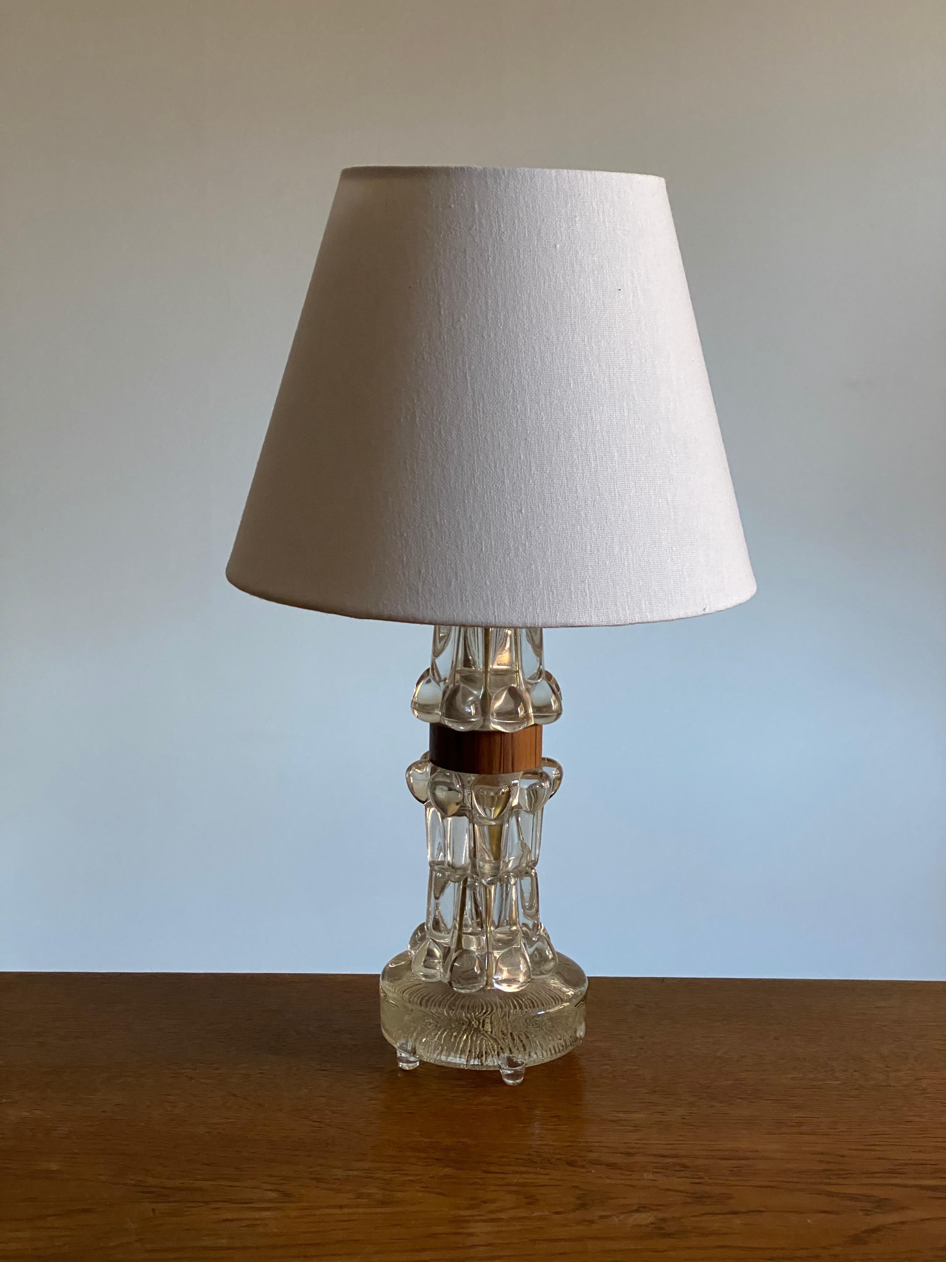 A highly modernist organic table lamp. Of Swedish production. In highly ornamented art glass, including a wooden ribbon in jacaranda or rosewood veneer.

Lampshade in the first two images is not included in the purchase. Stated measurements are