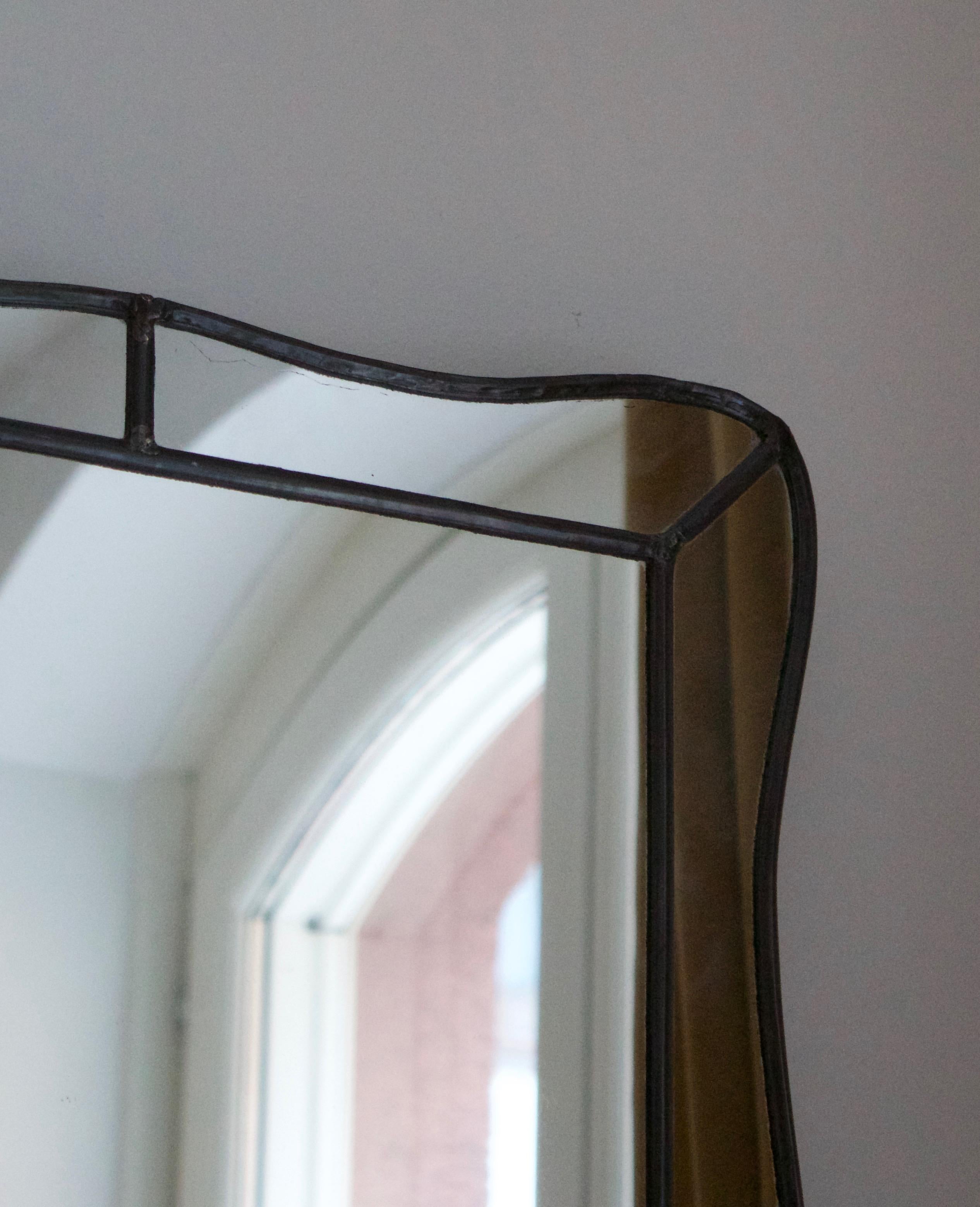 An organic wall mirror. Designed and produced in Sweden, 1940s. In pewter original mirror glass, over painted wood.

 