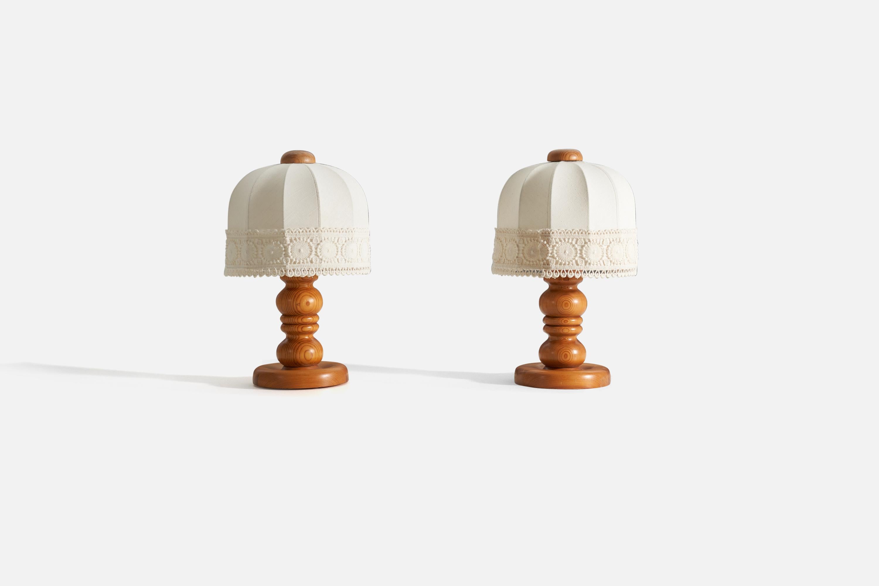 A pair of table lamp, designed and produced in Sweden, 1970s. In solid turned pine, original fabric lampshades. 

