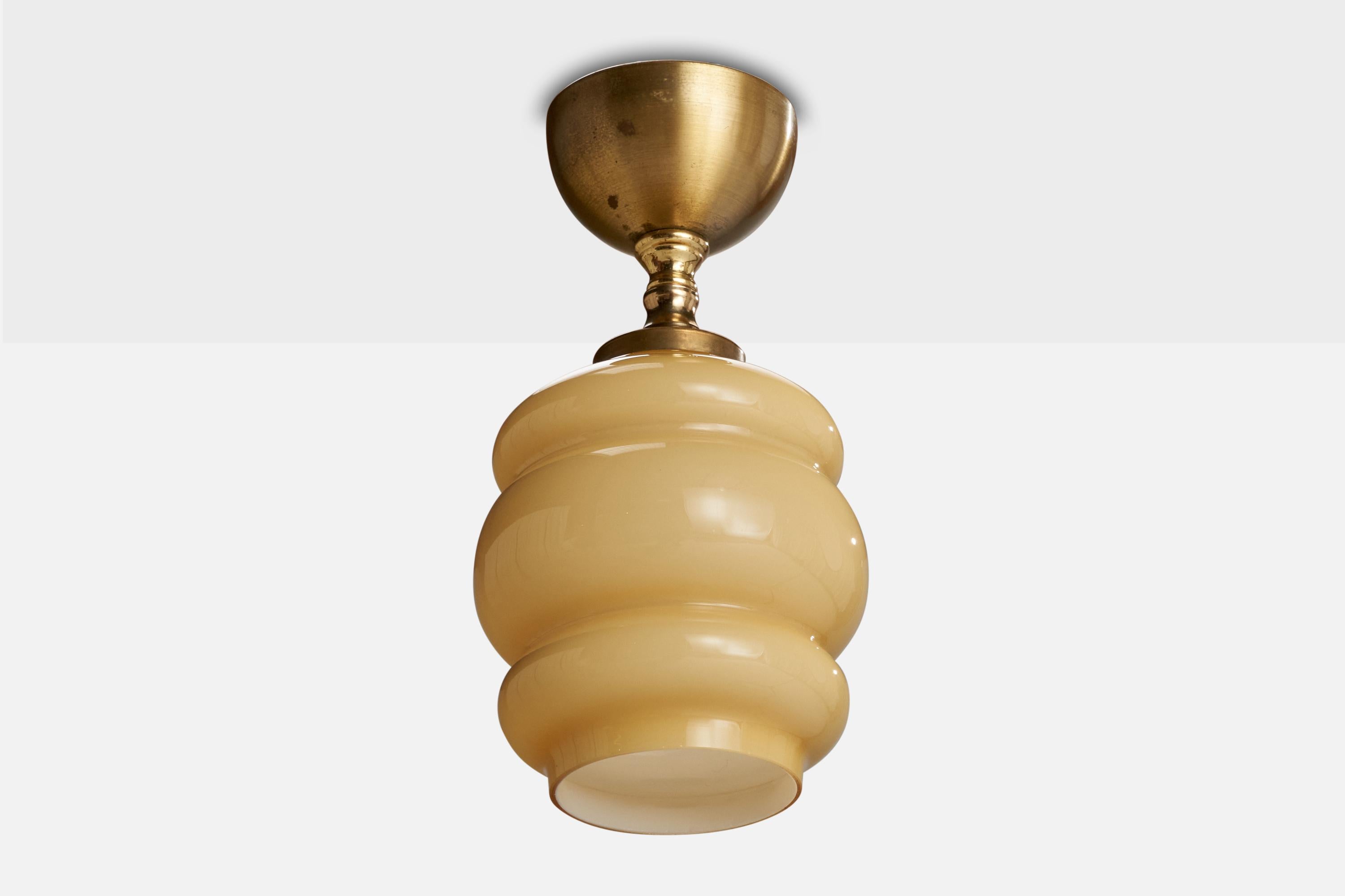 A brass and beige glass pendant light designed and produced in Sweden, c. 1950s.

Dimensions of canopy (inches): 3.65” H x 1.78” Diameter
Socket takes standard E-26 bulbs. 1 socket.There is no maximum wattage stated on the fixture. All lighting will