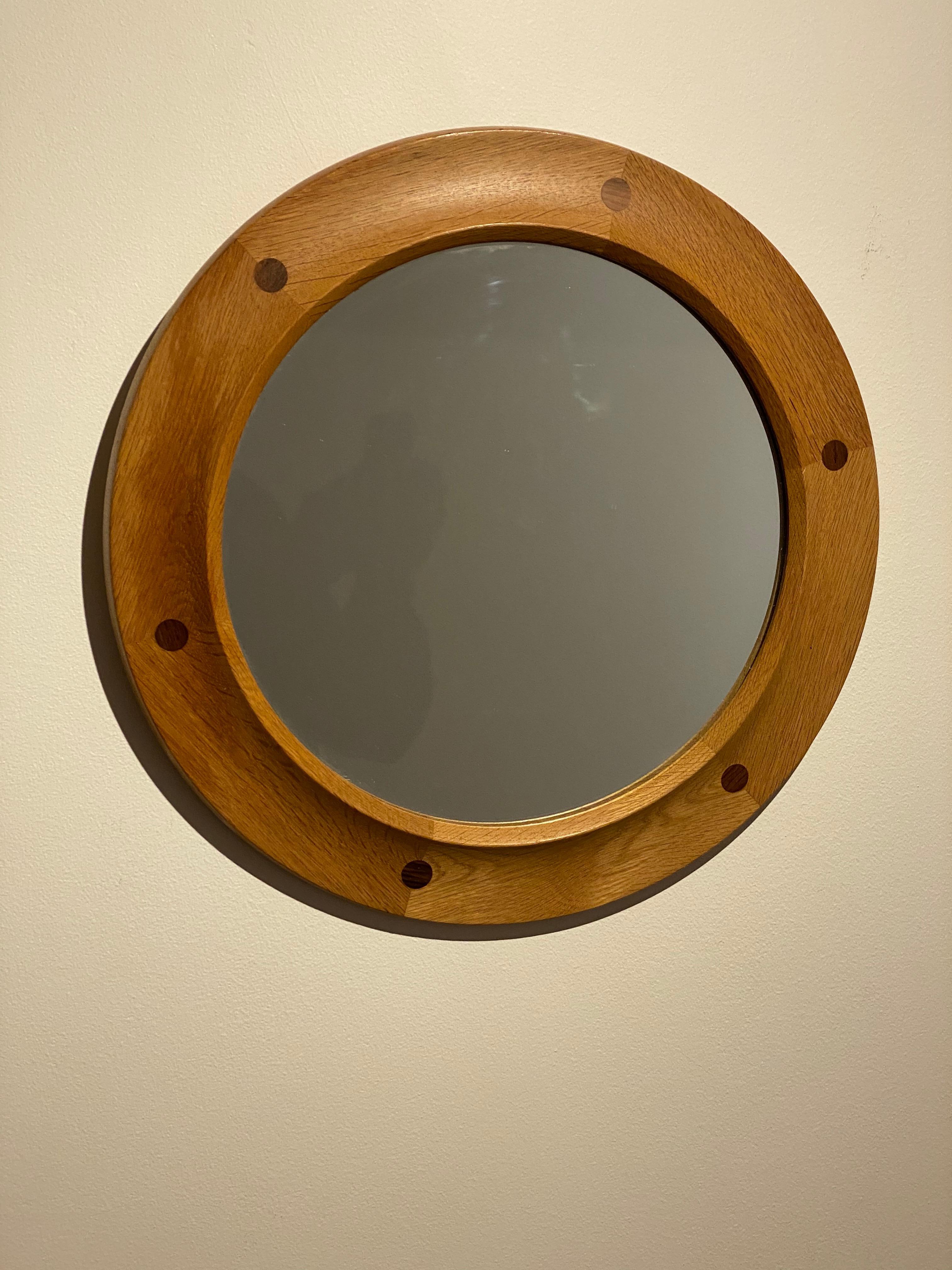 A stained oak mirror, glass with a finely sculpted oak frame wrapping the glass in a round form. Features superb teak joinery. Produced by Fröseke, AB Nybrofabriken. Model 