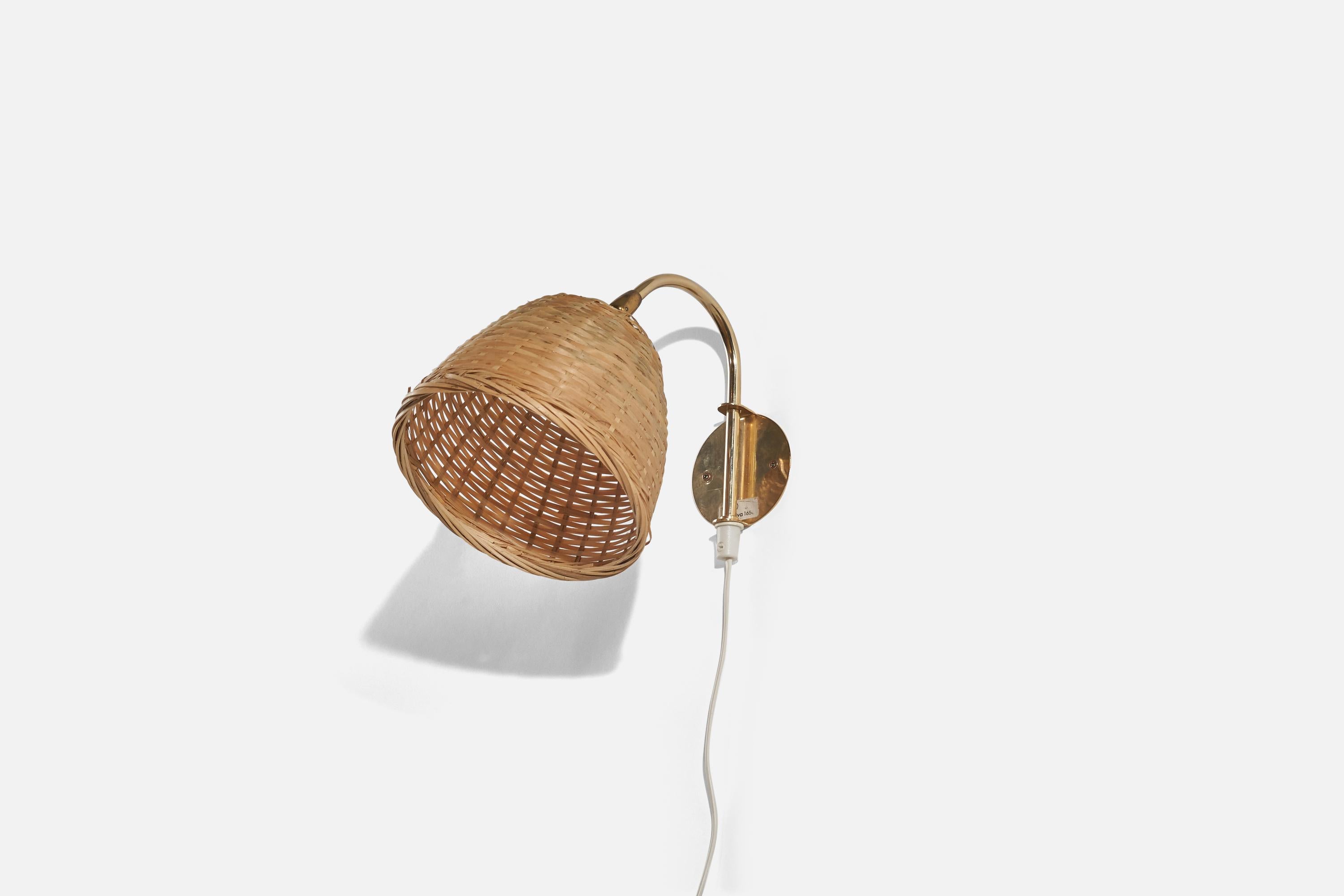 Applique in ottone e rattan progettata e prodotta in Svezia, anni '60 circa. 

Venduto con paralume. 
Le dimensioni dello stato si riferiscono alla scocca con paralume. 
Dimensioni variabili, misurate come illustrato nella prima immagine.