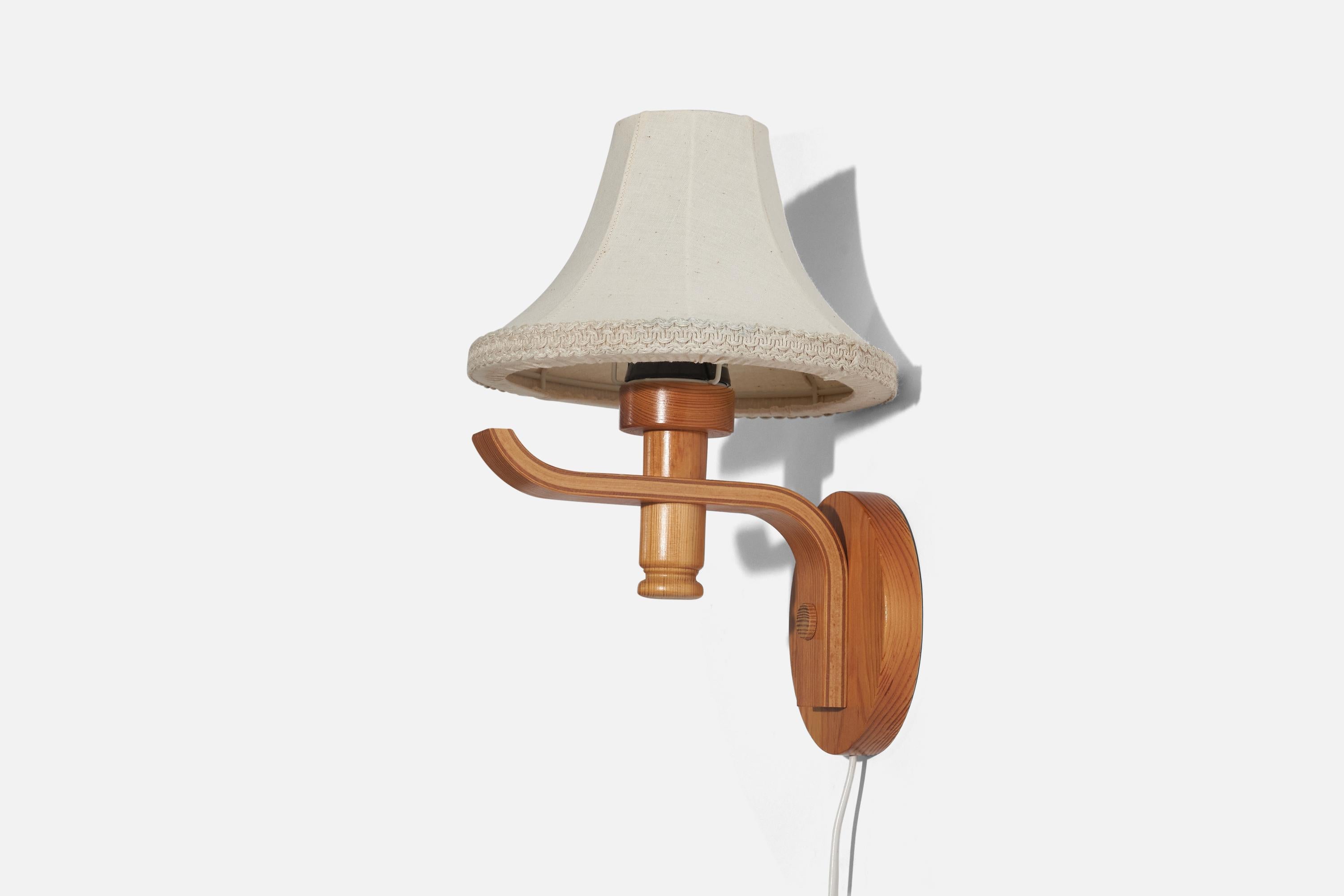 A pine and fabric sconce designed and produced in Sweden, c. 1970s. 

Sold with Lampshade. 
Stated dimensions refer to the Sconce with the Shade.
Dimensions of back plate (inches) : 5.45 x 5.45 x 0.81 (Height x Width x Depth).

Socket takes standard