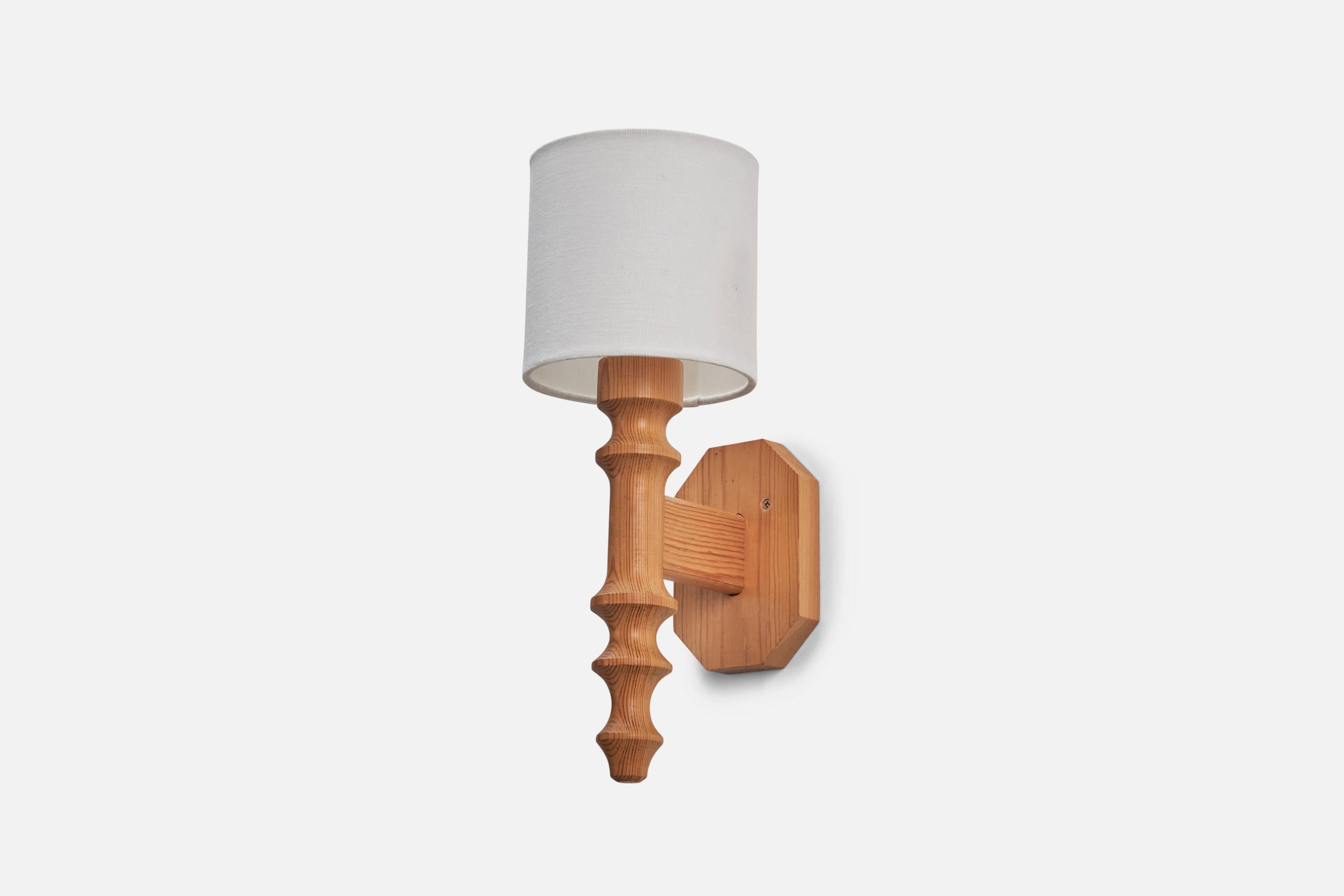 A pine and fabric sconce / wall light designed and produced in Sweden, c. 1970s. 

Sold with lampshade. 
Stated dimensions refer to the sconce with the shade.
Dimensions of back plate (inches) : 5.12 x 2.54 x 0.79 (height x width x