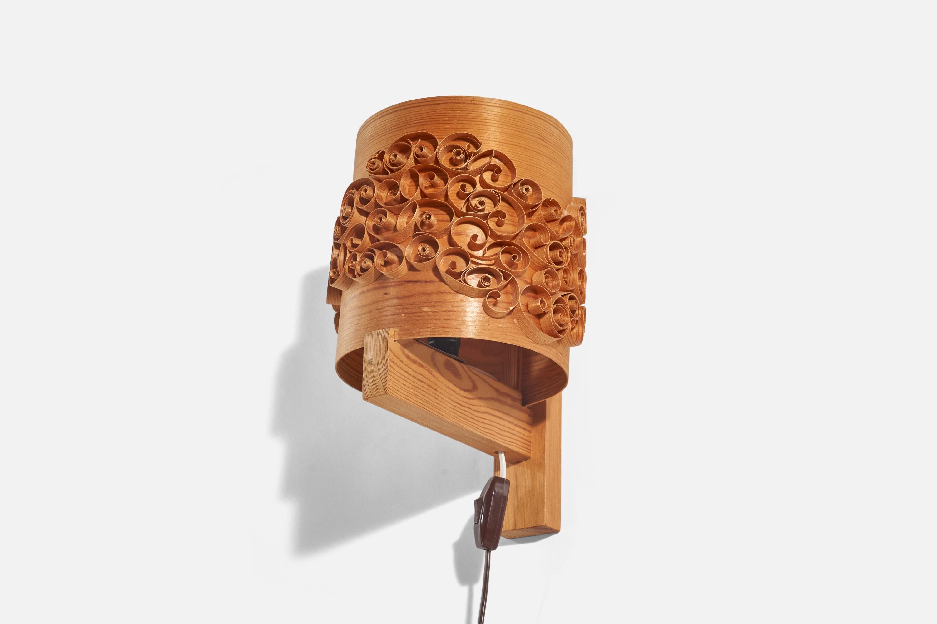 A pine and moulded pine-veneer sconce / wall light designed and produced in Sweden, 1970s.

Dimensions of Back Plate (inches) : 13.81 x 2 x 0.94 (Height x Width x Depth).

Socket takes E-14 bulb.

There is no maximum wattage stated on the