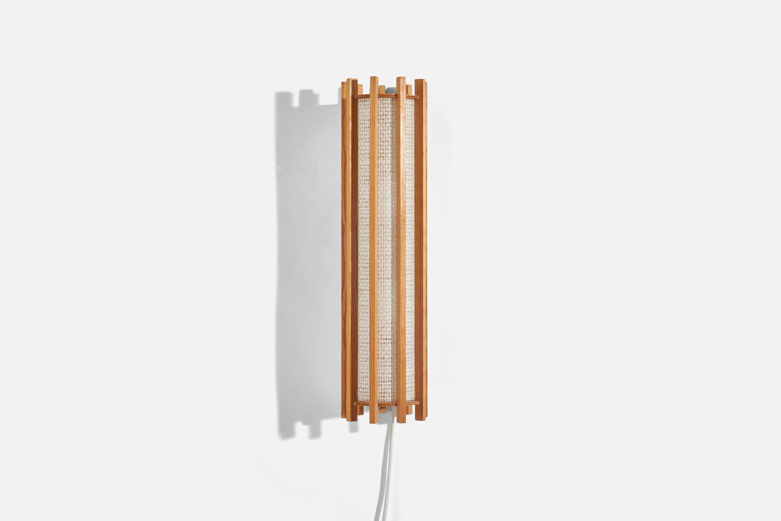 A pine and raffia sconce/ wall light designed and produced in Sweden, 1970s.

Dimensions of Back Plate (inches) : 14.5 x 1.6 x 0.56 (Height x Width x Depth)

Socket takes E-14 bulb.

There is no maximum wattage stated on the fixture.