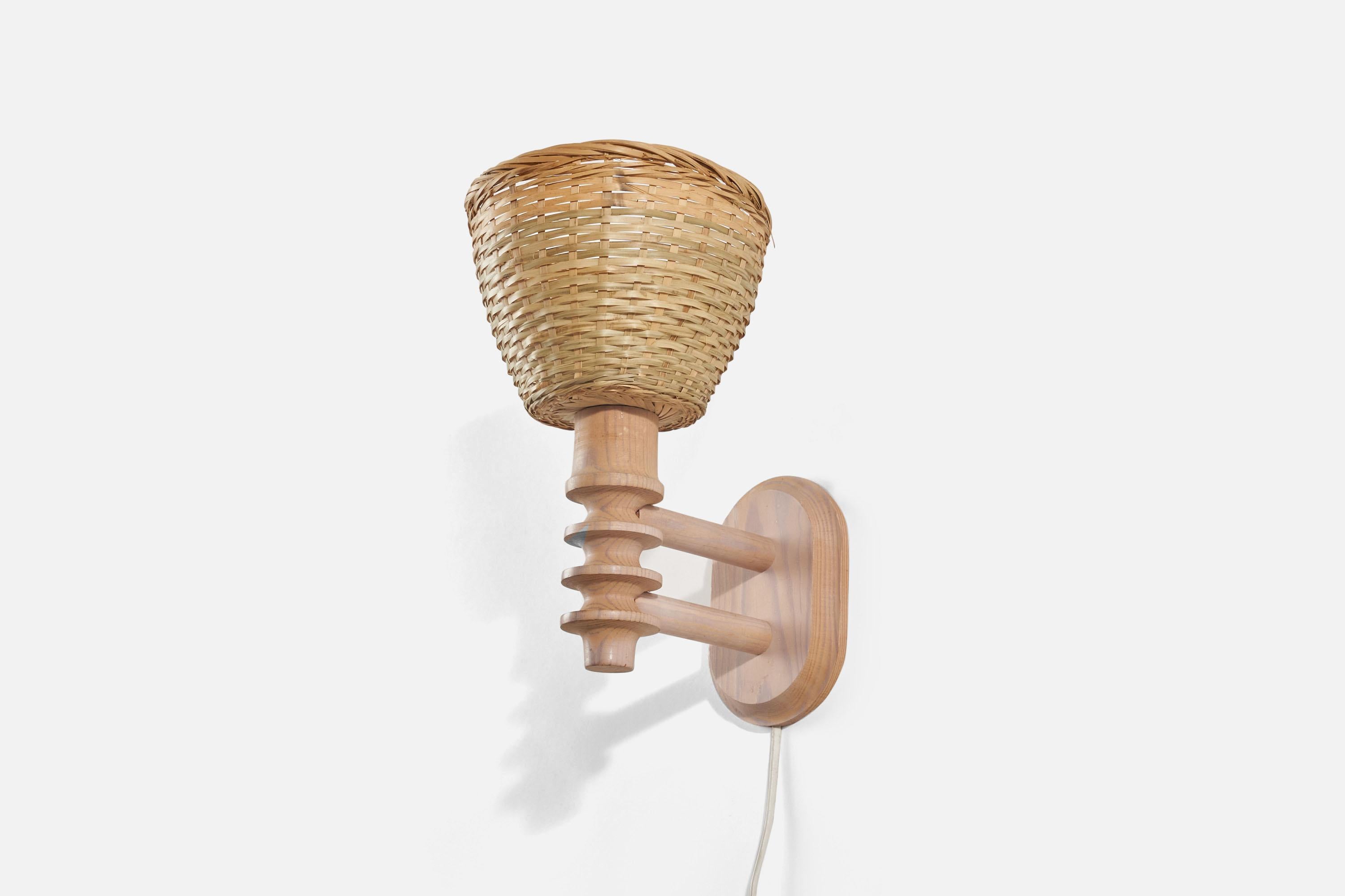 A pine and rattan sconce / wall light designed and produced in Sweden, 1960s.

Sold with lampshade(s). Dimensions stated are of Sconce with Shade(s).

Dimensions of back plate (inches) : 5.96 x 4 x 0.80 (Height x Width x Depth)

Socket takes