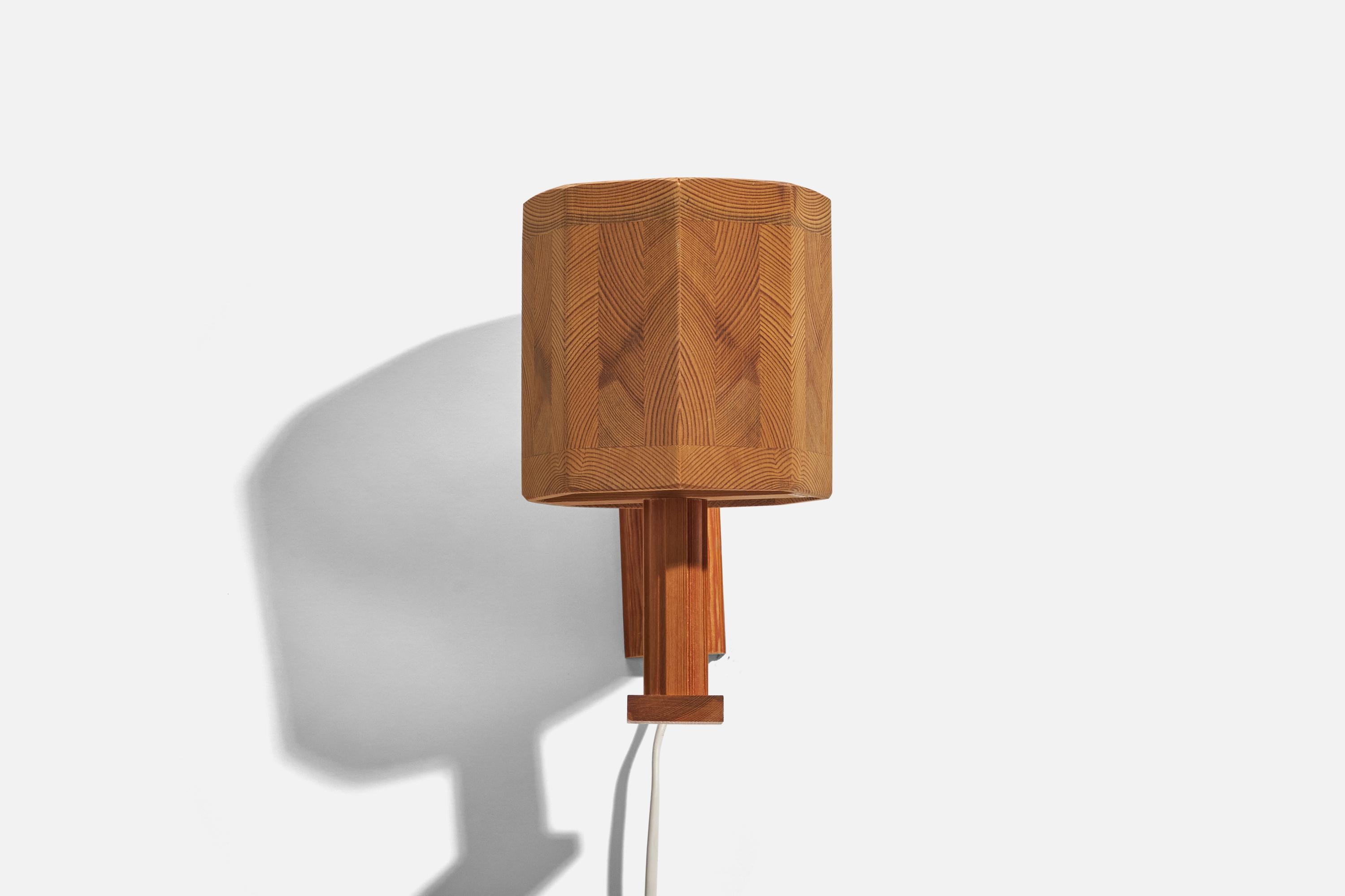 A pine sconce designed and produced in Sweden, 1970s. 

Dimensions of Back Plate (inches) : 4.94 x 1.79 x 0.54 (Height x Width x Depth)

Socket takes standard E-26 medium base bulb.

There is no maximum wattage stated on the fixture.
