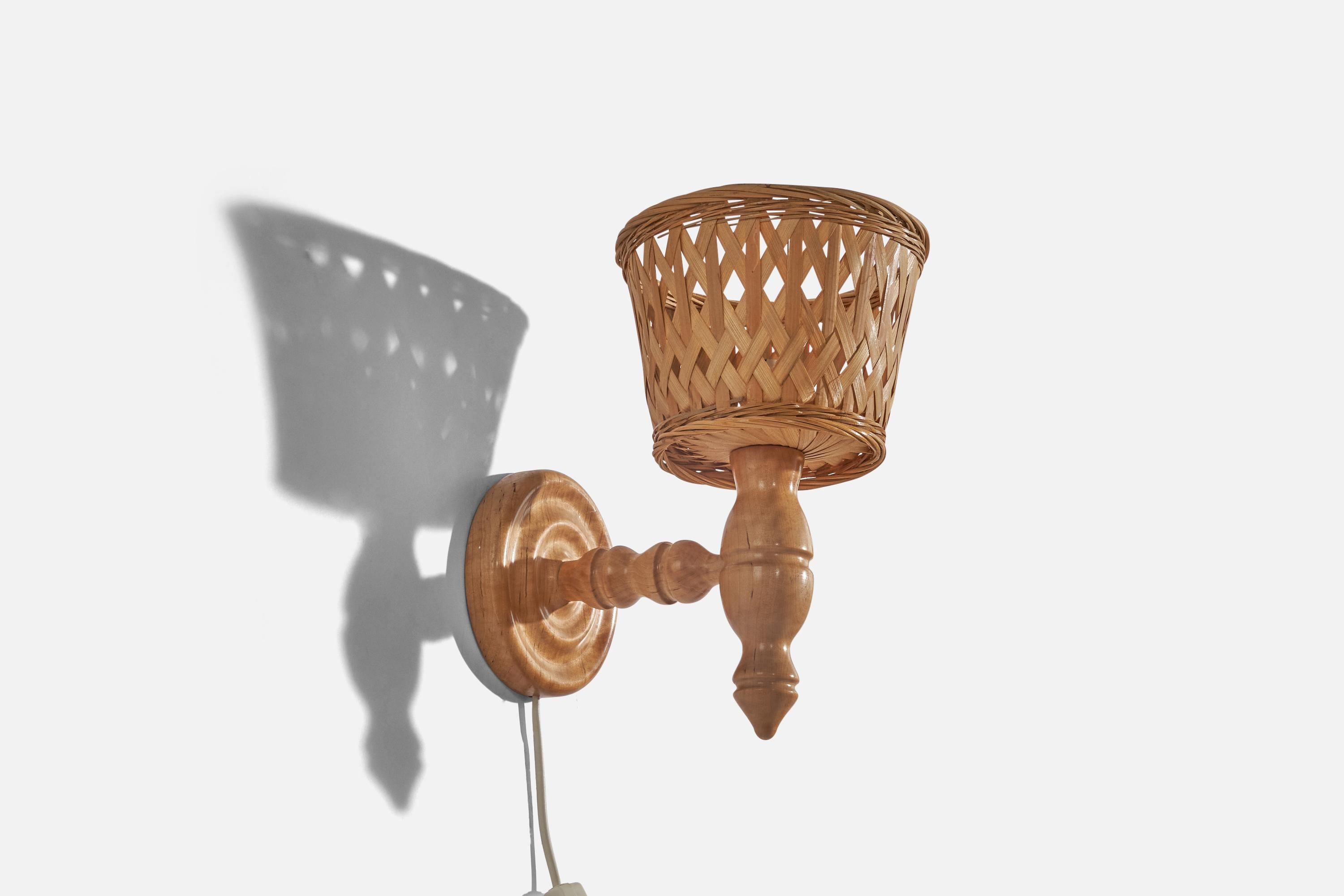 A pair of pine and rattan wall lights designed in Sweden, c. 1970s. 

Sold with lampshades. 
Stated dimensions refer to the Sconces with the Shades.
Dimensions of back plate (inches) : 5.23 x 5.23 x 1.03 (Height x Width x Depth).