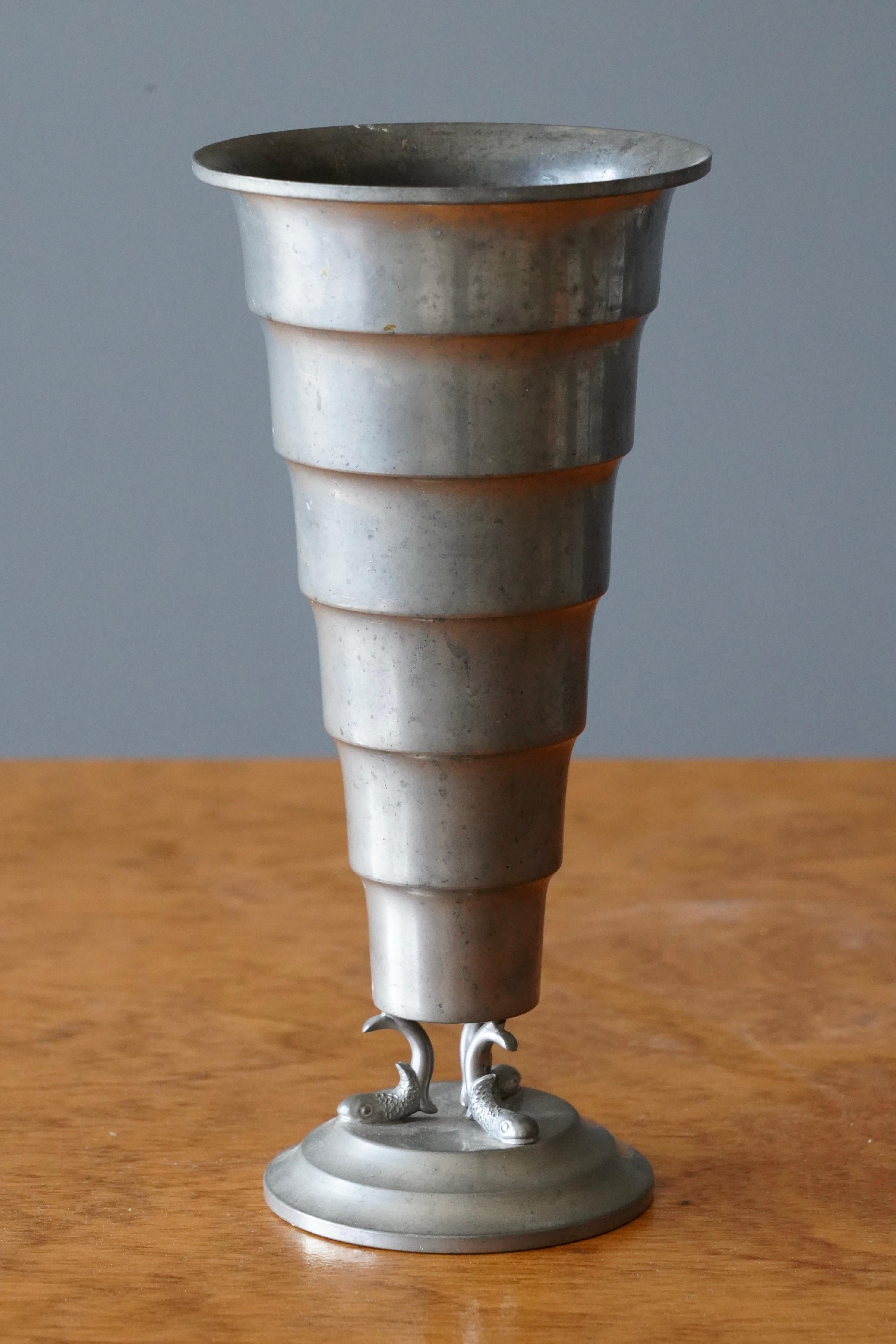 A vase, produced by Svenskt Tenn, features multiple engravings stamped with makers mark, Sweden, 1930s. In cast pewter. Features sculptural fish motifs.

Other designers of the period include Josef Frank, Kaare Klint, Estrid Ericson, and Just