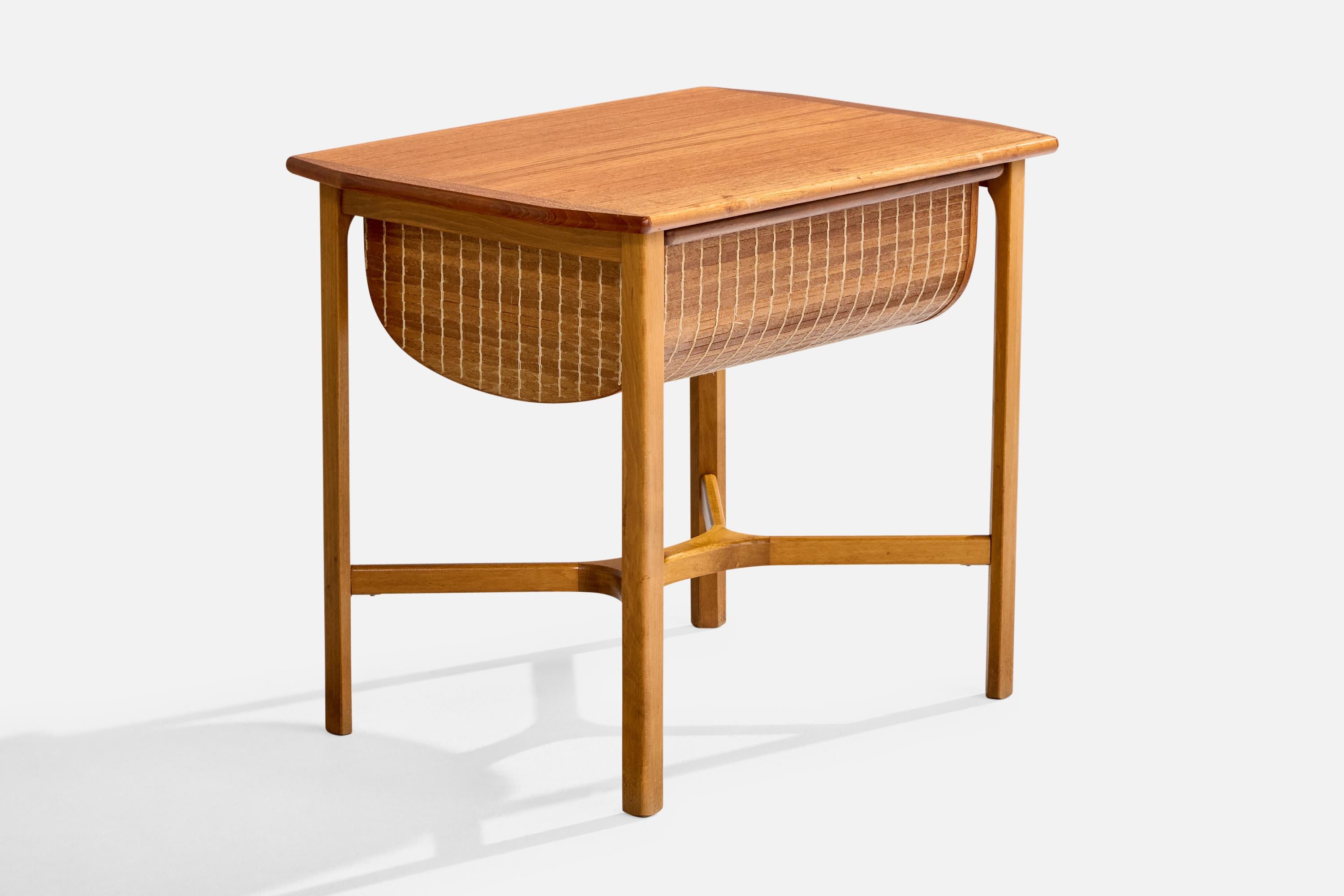 Ein Nähtisch oder Beistelltisch aus Teakholz und geflochtenem Schilfrohr, entworfen und hergestellt in Schweden, ca. 1950er Jahre.

Gesamtabmessungen (Zoll): 19,625 