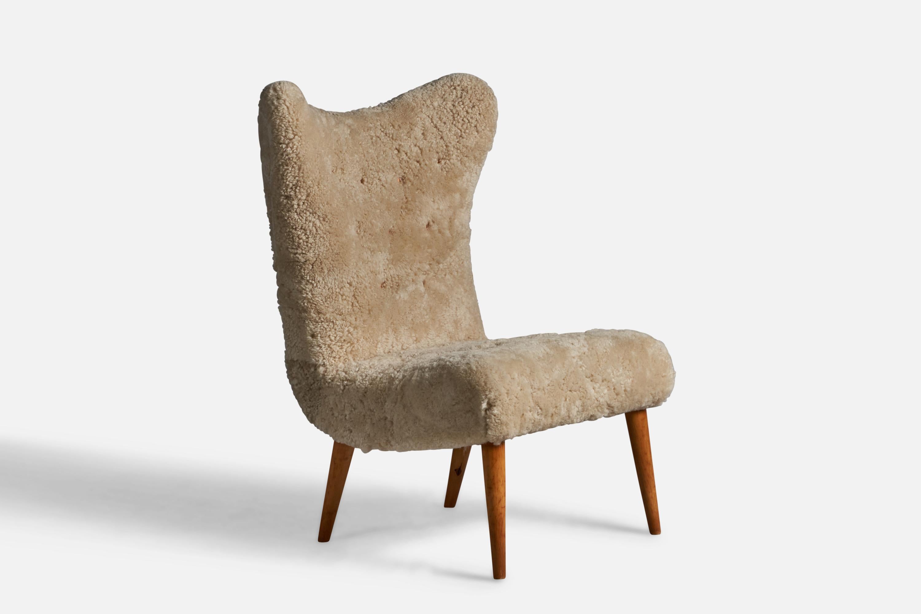 A wood and beige shearling lounge chair designed and produced in Sweden, 1950s.

16