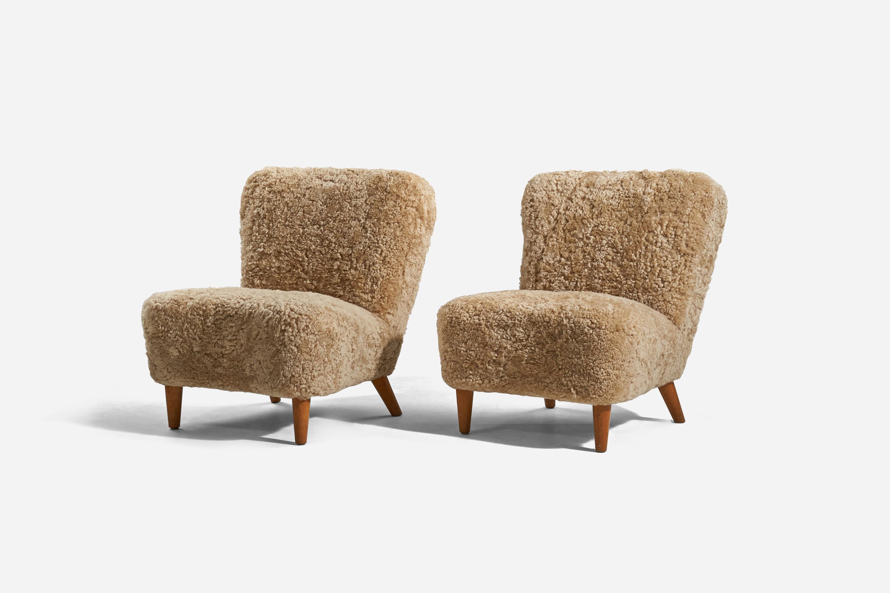 A pair of sheepskin and wood slipper chairs designed and produced in Sweden, 1940s.
 