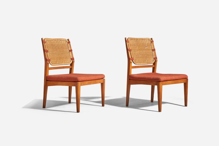 A pair of stained beech, rattan and orange fabric slipper chairs designed and produced in Sweden, 1950s. 



 