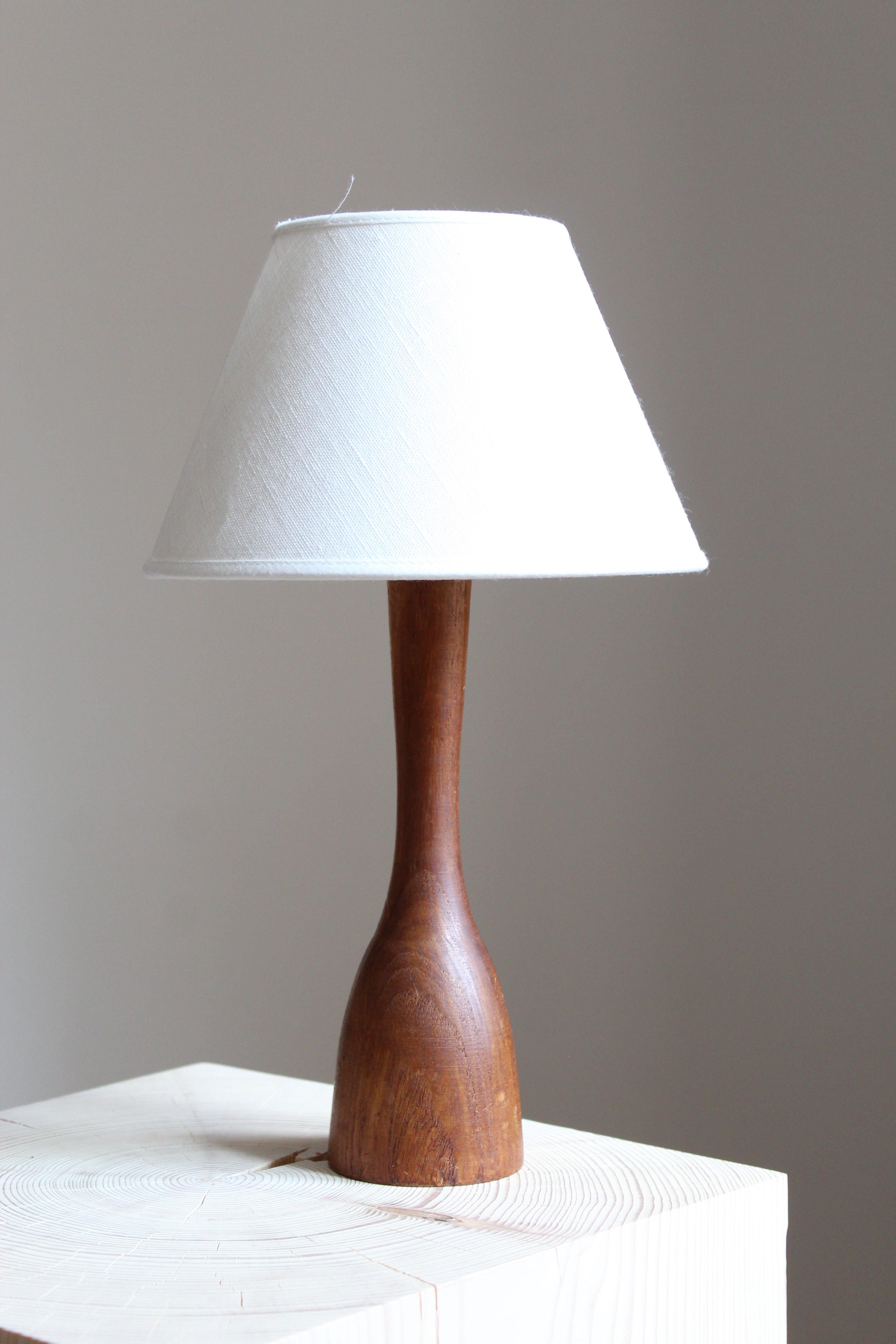 A table lamp. Designed and produced in Sweden, 1960s. In solid teak. Shade not included.
 
 