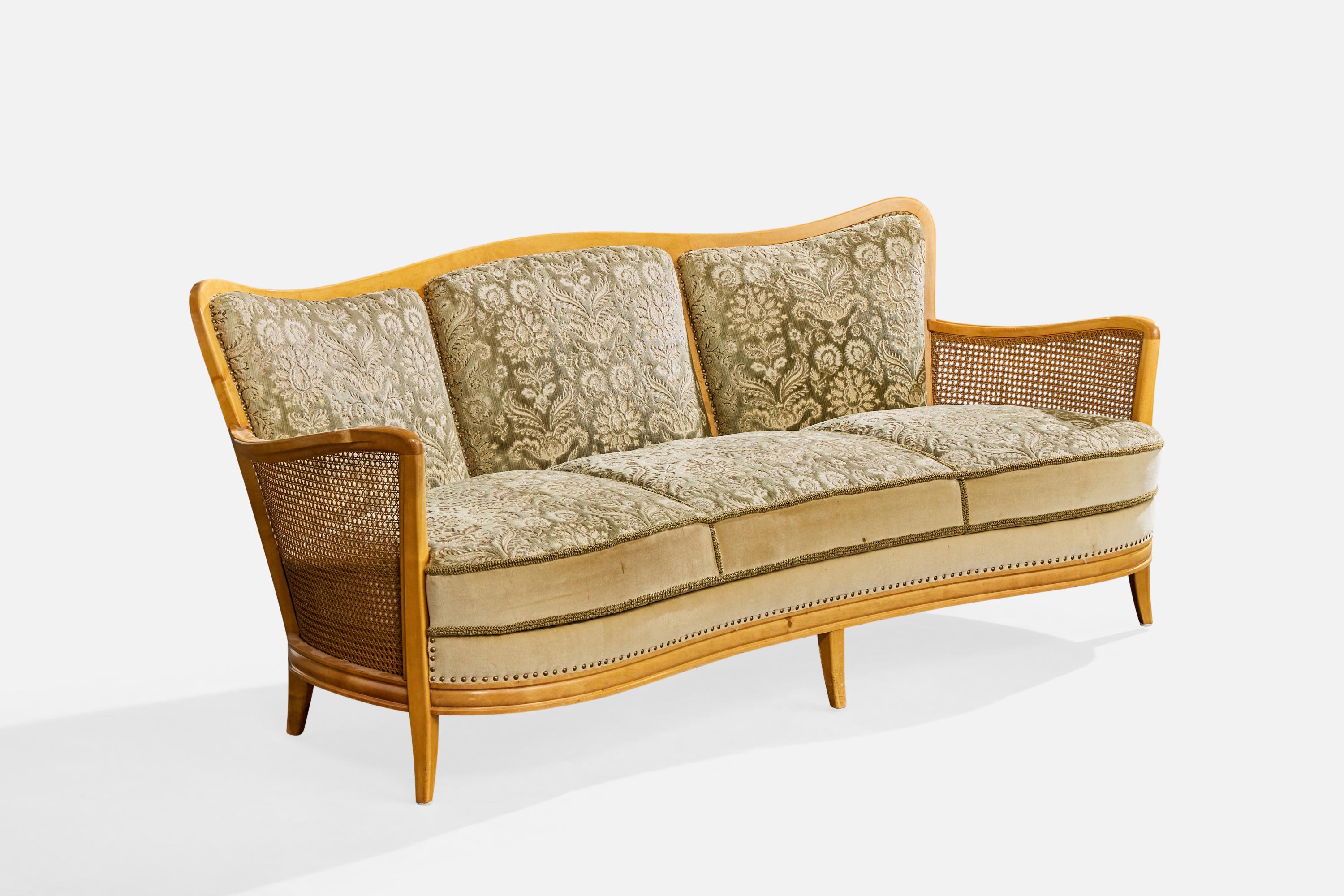 Canapé en bouleau, canne et tissu, conçu et produit en Suède, c.C. années 1930.

Le tissu, le cadre en bois et le cannage ont été usés par le temps et le tissu est dans un état moyen à dégradé.

Patine sur les têtes de clous des bordures