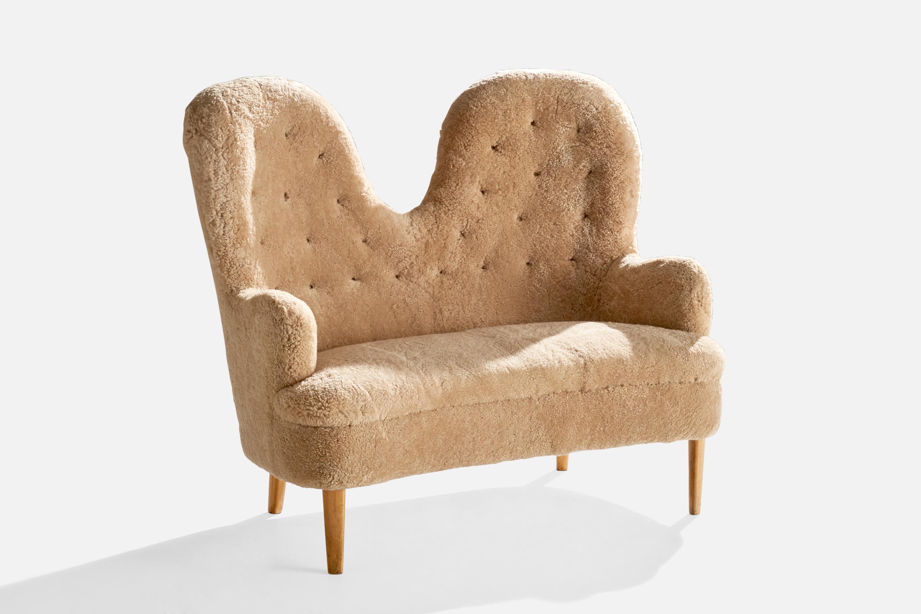 An organic shearling and wood sofa designed and produced in Sweden, c. 1940s.

Seat Height: 18