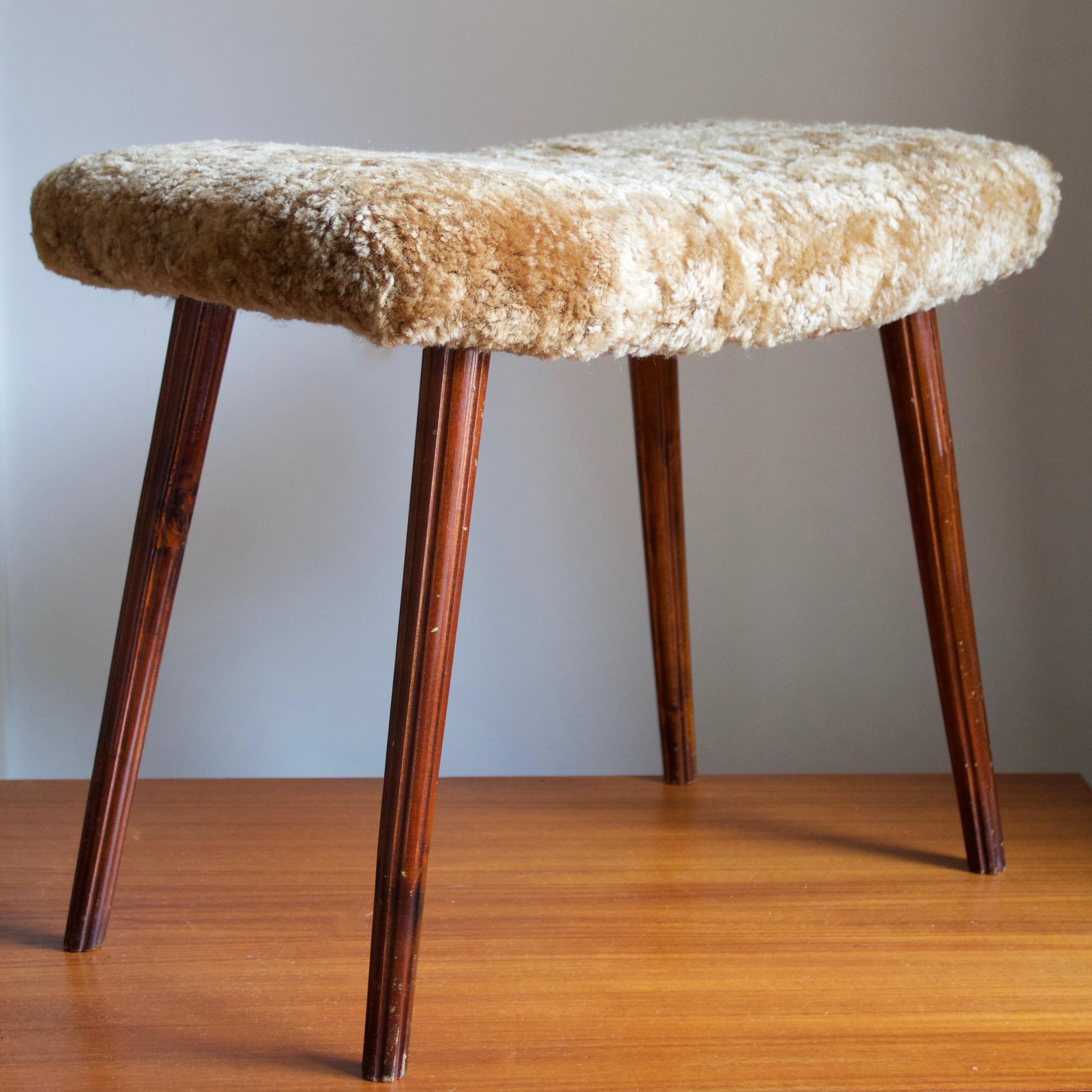 A stool in dark stained wood with simple carved ornamentation, overstuffed seat reupholstered in brand new sheepskin upholstery. Produced in Sweden, 1950s.

Other designers of the period include Finn Juhl, Hans Wegner, Isamu Noguchi, Charlotte