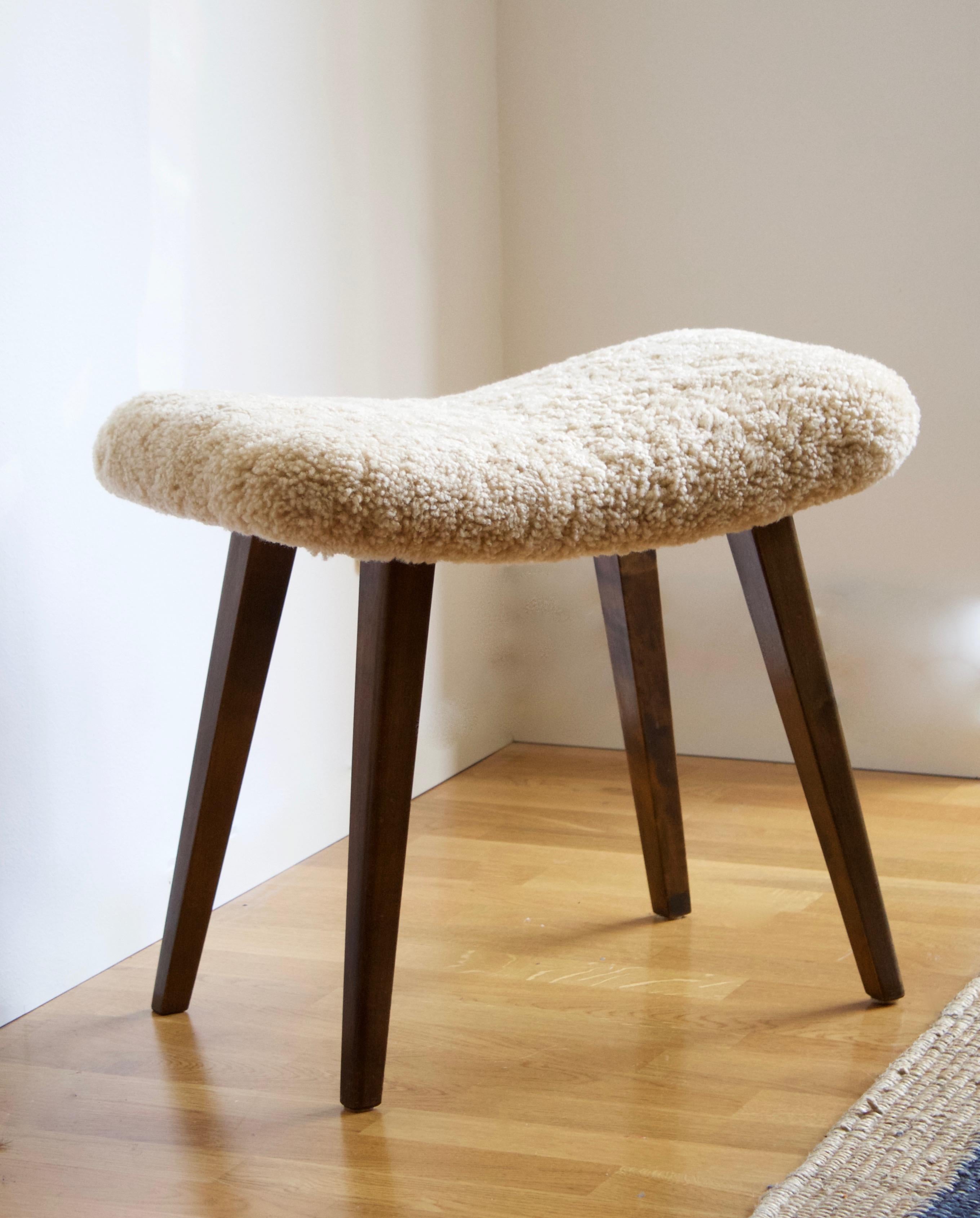 A stool in dark stained wood, overstuffed seat reupholstered in brand new authentic sheepskin upholstery. Produced in Sweden, 1950s.

Other designers of the period include Finn Juhl, Hans Wegner, Isamu Noguchi, Charlotte Perriand.