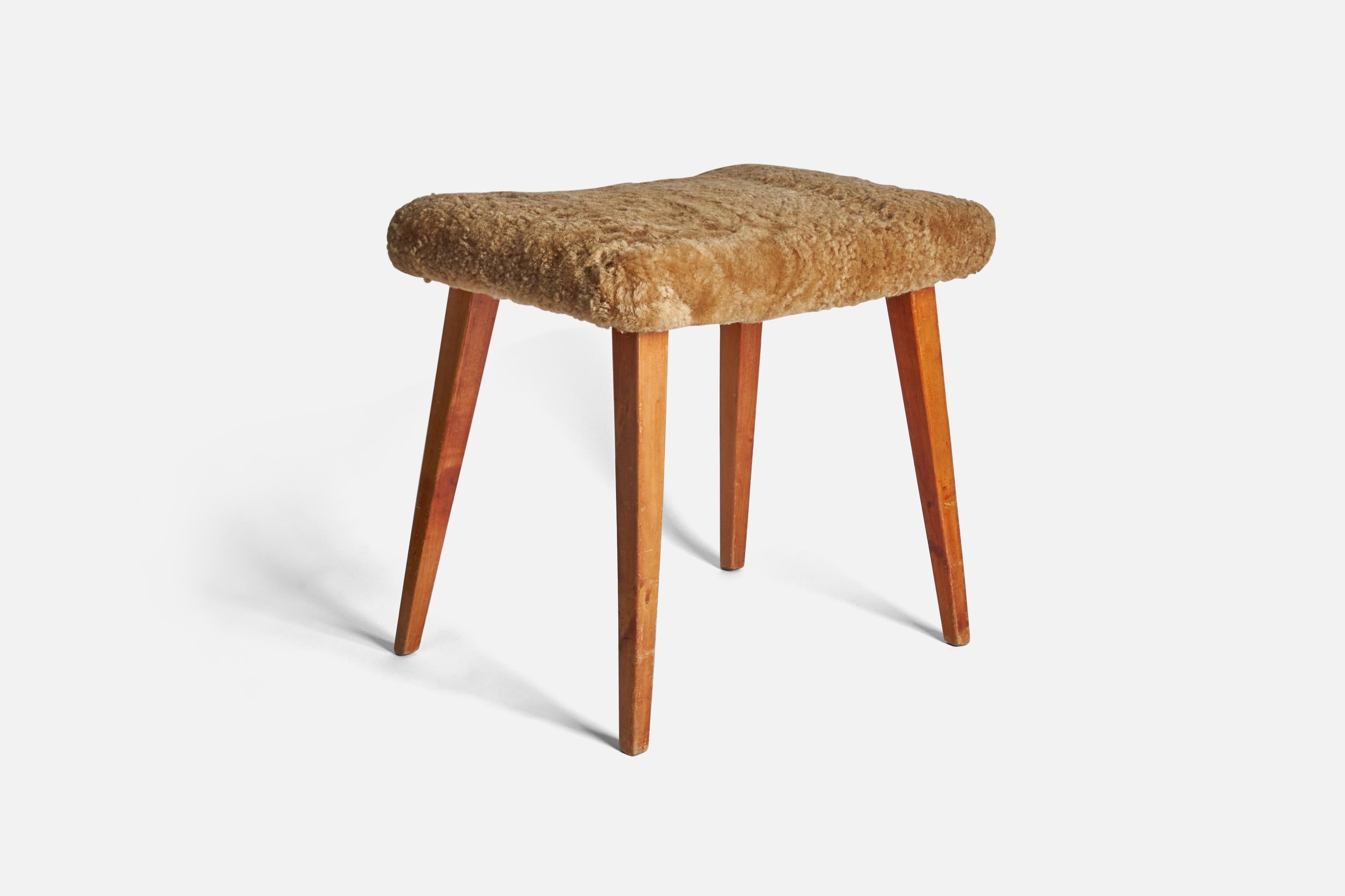 A stained oak and beige sheepskin stool designed and produced in Sweden, 1950s.

