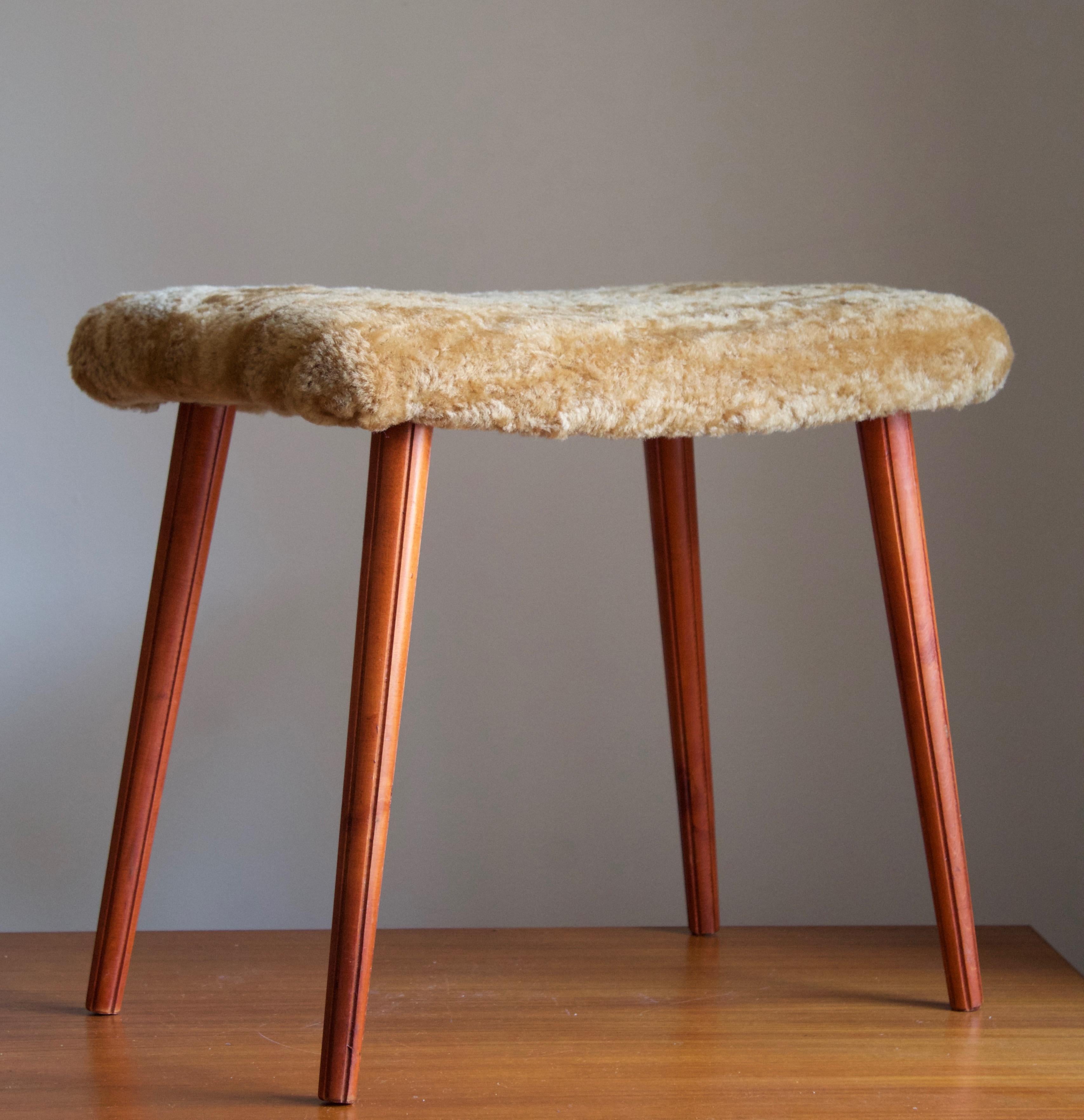 A stool in stained wood with carved fluted ornamentation, overstuffed seat reupholstered in brand new sheepskin upholstery. Produced in Sweden, 1950s.

Other designers of the period include Finn Juhl, Hans Wegner, Isamu Noguchi, Charlotte Perriand.