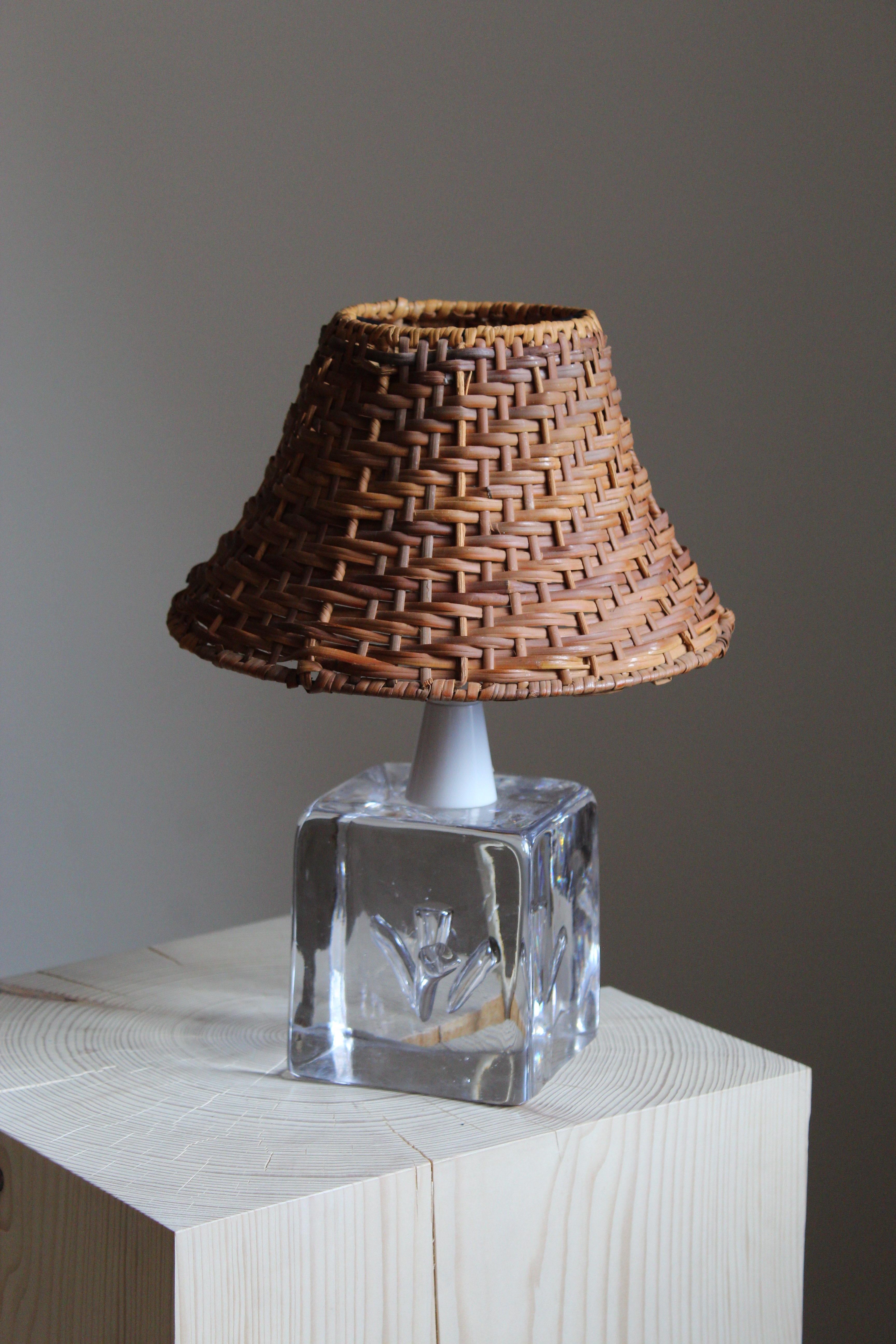 A table lamp designed and produced in Sweden, c. 1960s. Features blown glass. Assorted vintage lampshade in rattan.
 
  