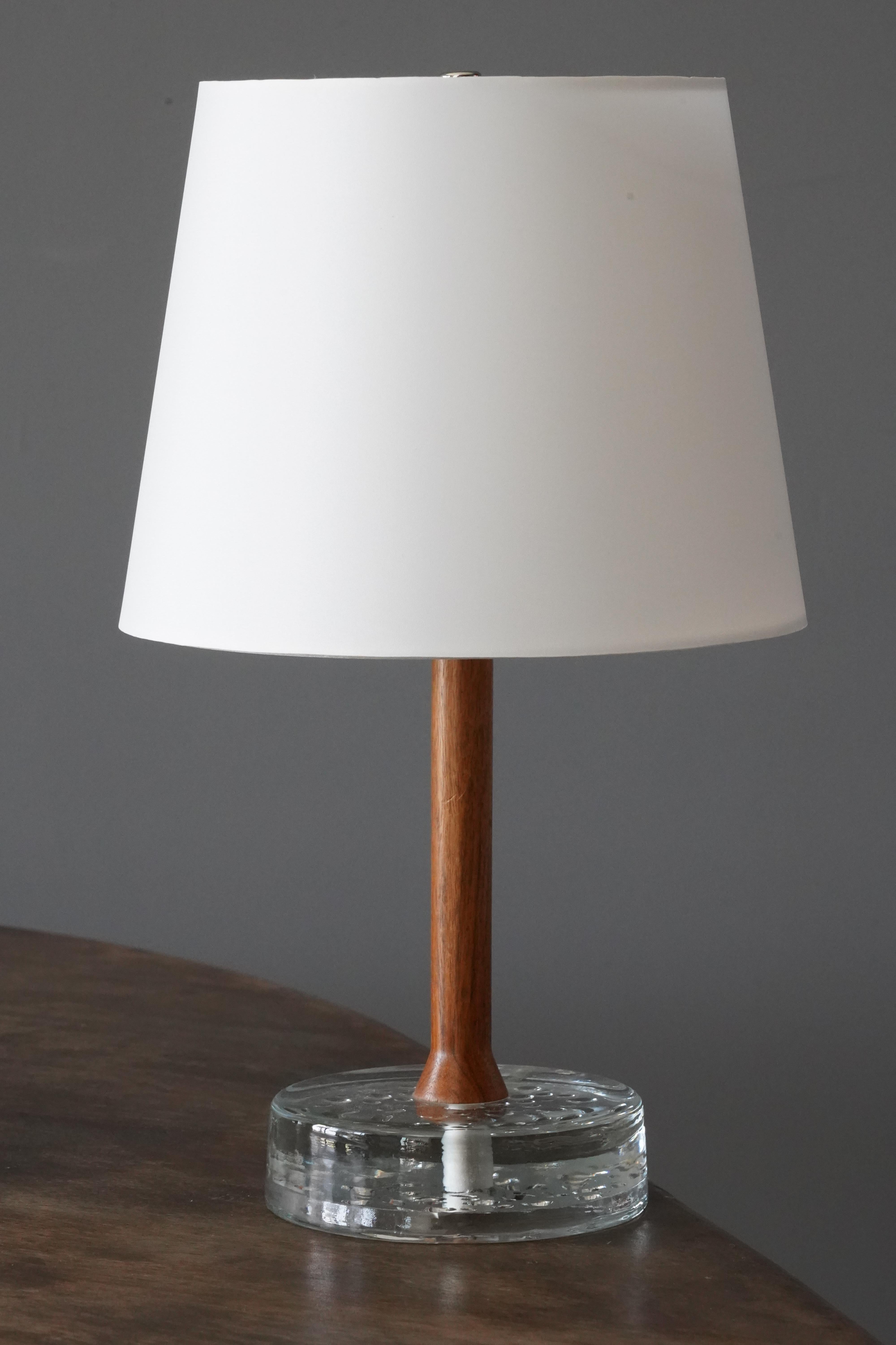 A table lamp, designed and produced in Sweden, c. 1960s. Features a blown glass base and a rosewood rod. 

Sold without lampshade, stated dimensions exclude lampshade, height includes socket.
