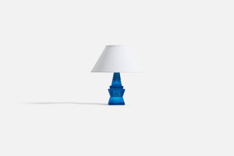 A blue glass table lamp designed and produced in Sweden, c. 1960s.

Measurements listed are of the lamp itself. Sold without lampshade.

For reference:
Measurements of shade : 5 x 12.25 x 7.25 - (T x B x S)
Overall measurements with shade : 12