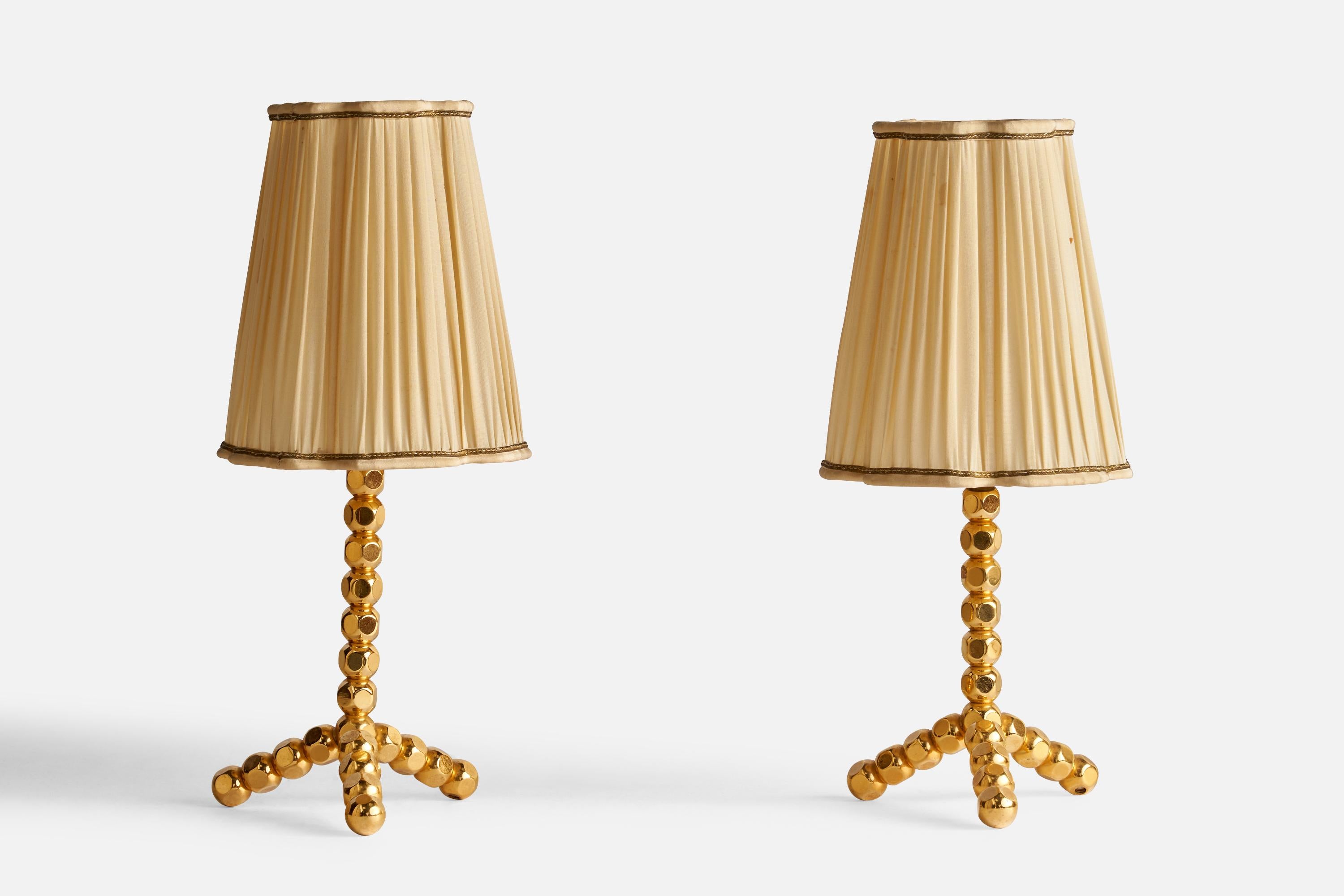 A pair of brass and beige fabric table lamps designed and produced in Sweden, 1970s.

Overall Dimensions (inches): 13.25” H x 5.6” Diameter
Bulb Specifications: E-14 Bulbs
Number of Sockets: 2
All lighting will be converted for US usage. We is