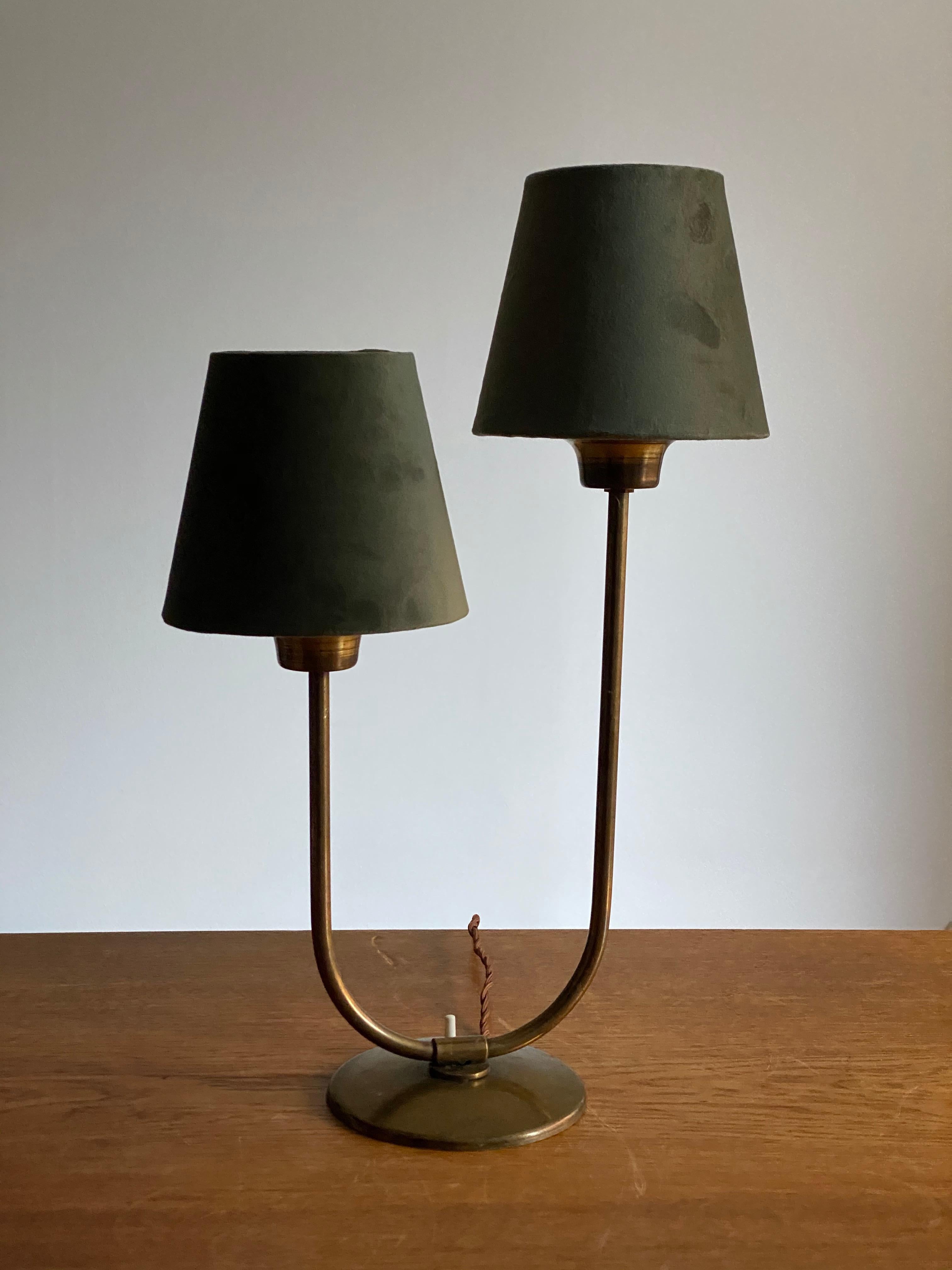 A table lamp or desk light. In brass, two armed. Lampshades in green velvet.

Other designers of the period include Josef Frank, Paavo Tynell, Hans Bergström, Böhlmarks.