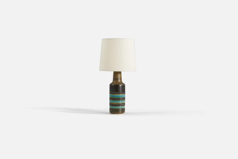 A brown and blue-glazed stoneware table lamp designed and produced in Sweden, 1960s.

Sold without lampshade 

Measurements listed are of lamp.
Shade : 7 x 8 x 7
Lamp with shade : 16.5 x 8 x 8.