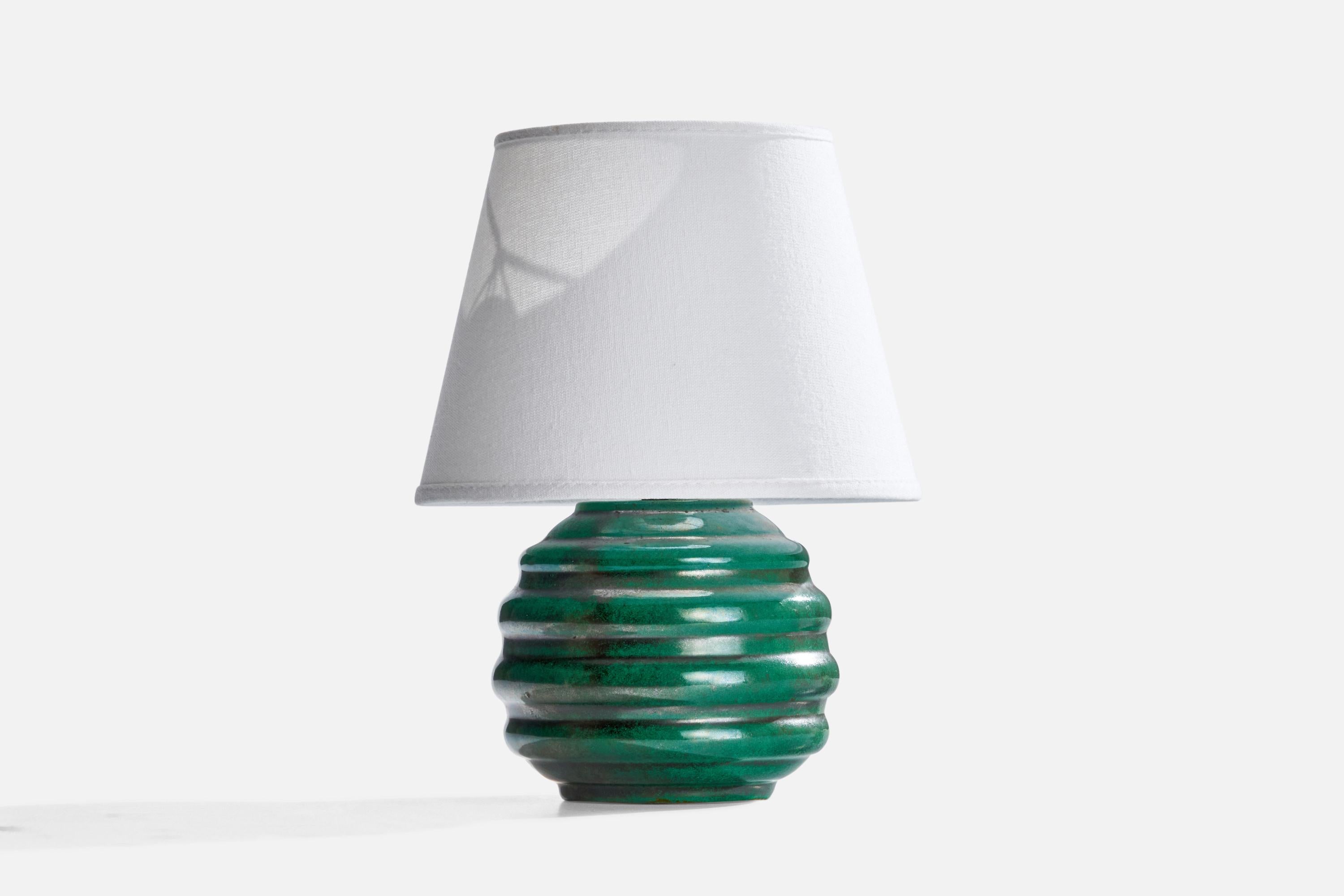 A green-glazed ceramic table lamp designed and produced in Sweden, c. 1930s.

Dimensions of Lamp (inches): 7” H x 5.25” Diameter
Dimensions of Shade (inches): 5”  Top Diameter x 8” Bottom Diameter x 6” H
Dimensions of Lamp with Shade (inches): 11” H
