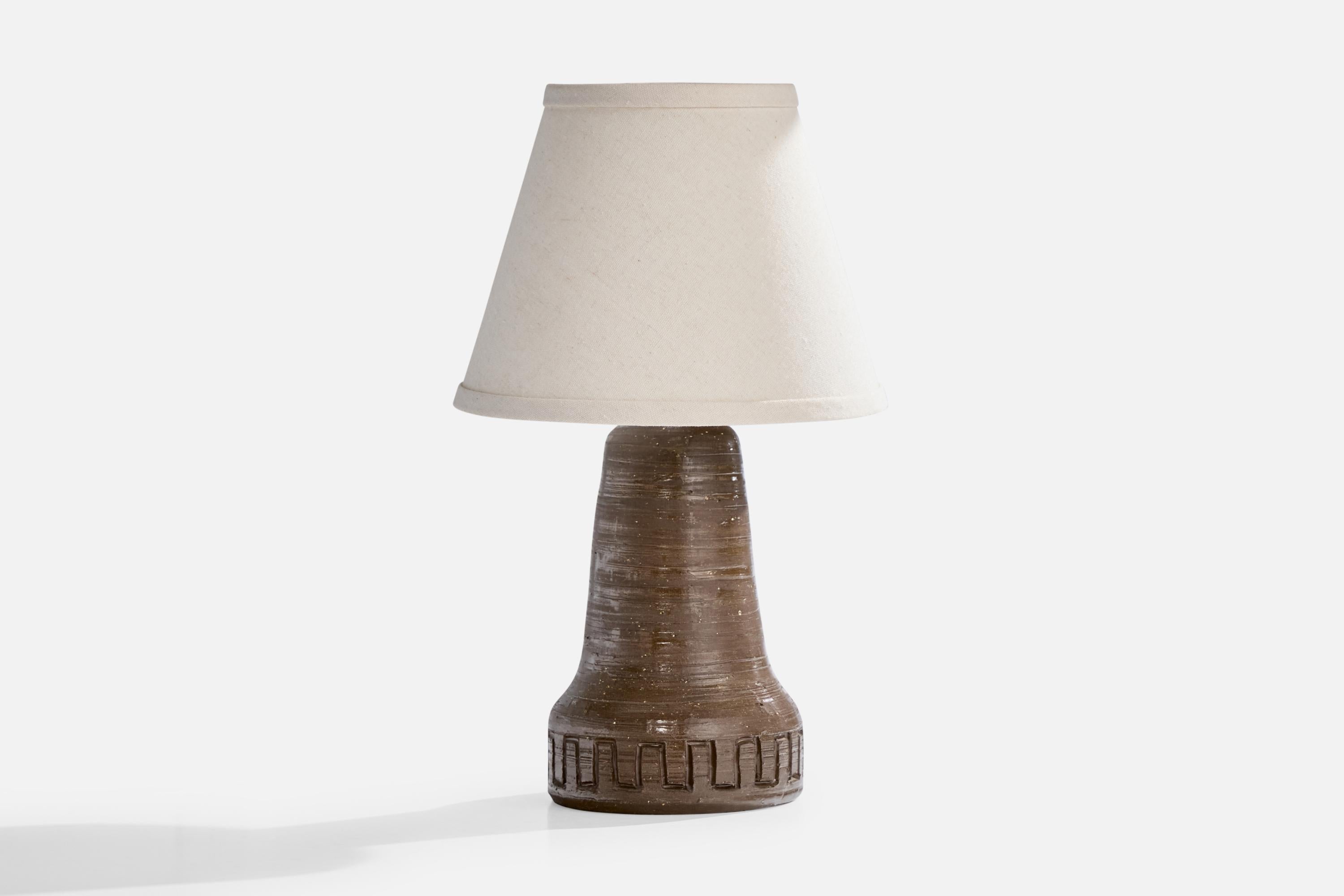 A brown-glazed and incised table lamp designed and produced in Sweden, signed I.H. Borås and dated 1967.

Dimensions of Shade: 5” Top Diameter x 9” Bottom Diameter x 7” Height

Dimensions of Lamp with Shade: 15” Height x 9” Diameter

Dimensions of