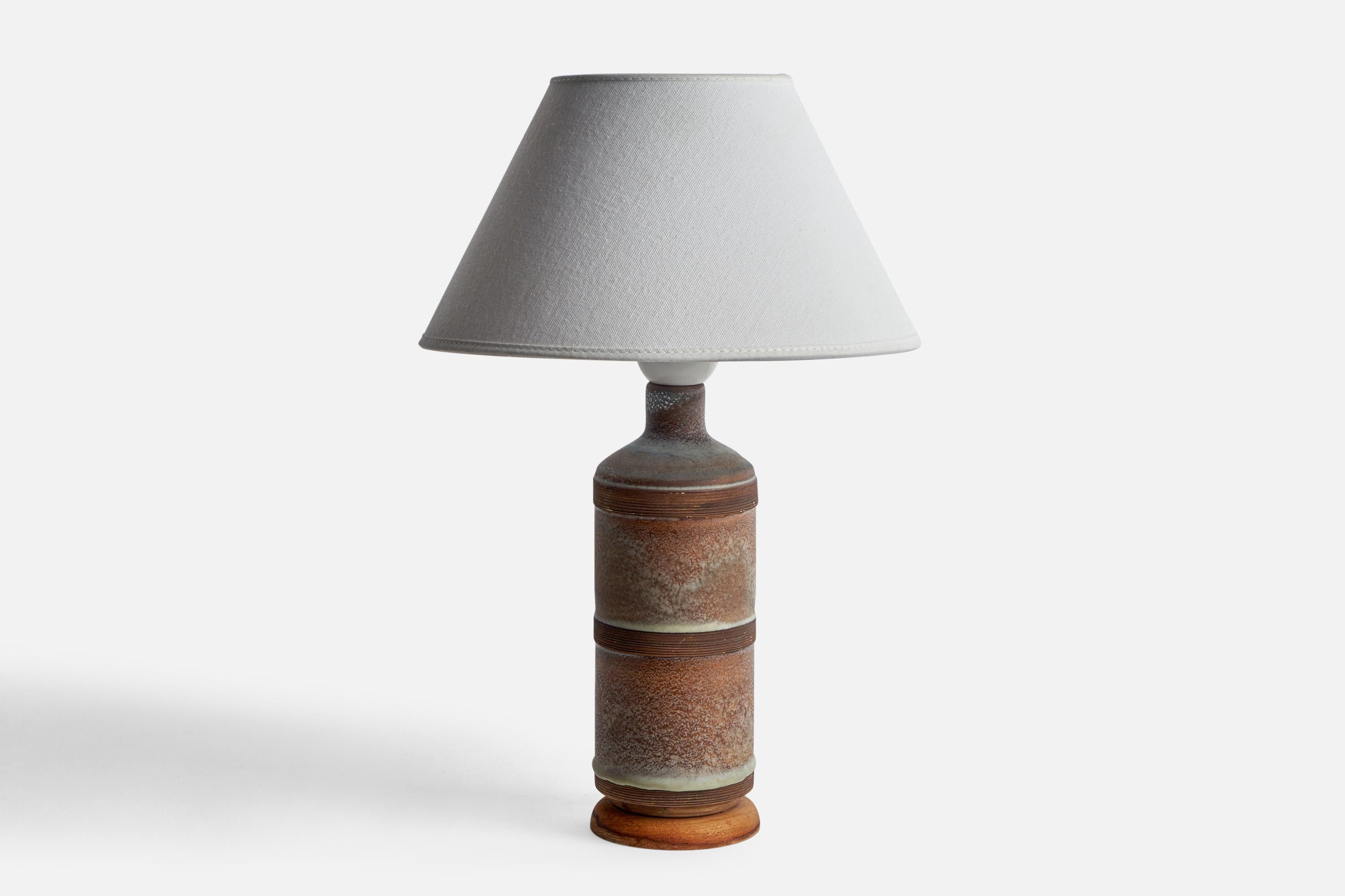 A grey and brown-glazed ceramic and wood table lamp designed and produced in Sweden, 1950s.

Dimensions of Lamp (inches): 11.7” H x 3.45” Diameter
Dimensions of Shade (inches): 4.5” Top Diameter x 10” Bottom Diameter x 5.25” H
Dimensions of Lamp