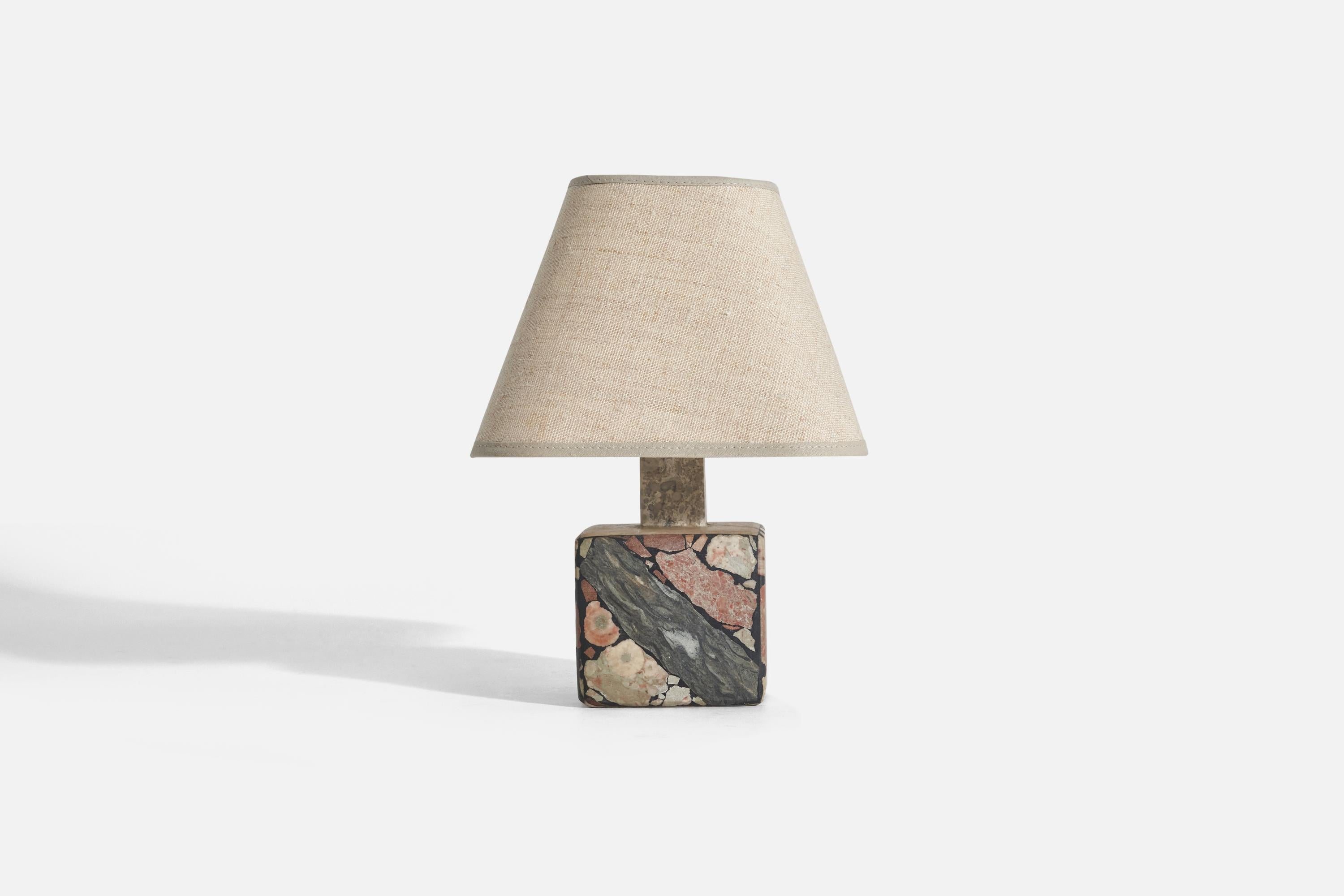 A solid stone table lamp with fossil pieces, Pietra Dura technique, designed and produced in Sweden, c. 1970s.

Sold with fabric Lampshade. 
Dimensions stated are of Lamp with Shade. 

Socket takes standard E-26 medium base bulb.
There is no