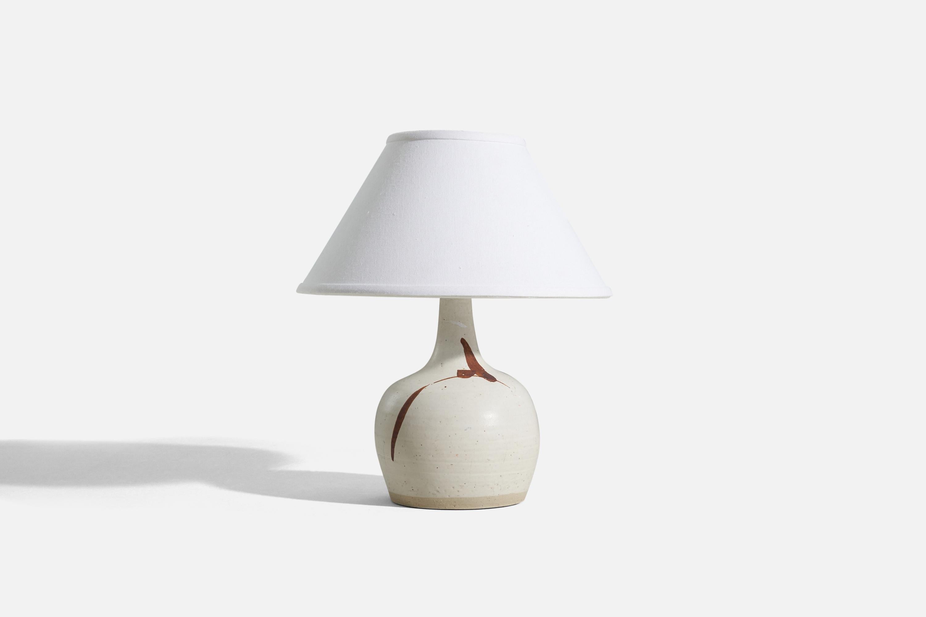 A white glazed stoneware table lamp, designed and produced by a Swedish designer, Sweden, 1960s.

Sold without lampshade. 
Dimensions of Lamp (inches) : 11.8125 x 6.375 x 6.375 (H x W x D)
Dimensions of Shade (inches) : 5 x 12.25 x 7.25 (T x B x