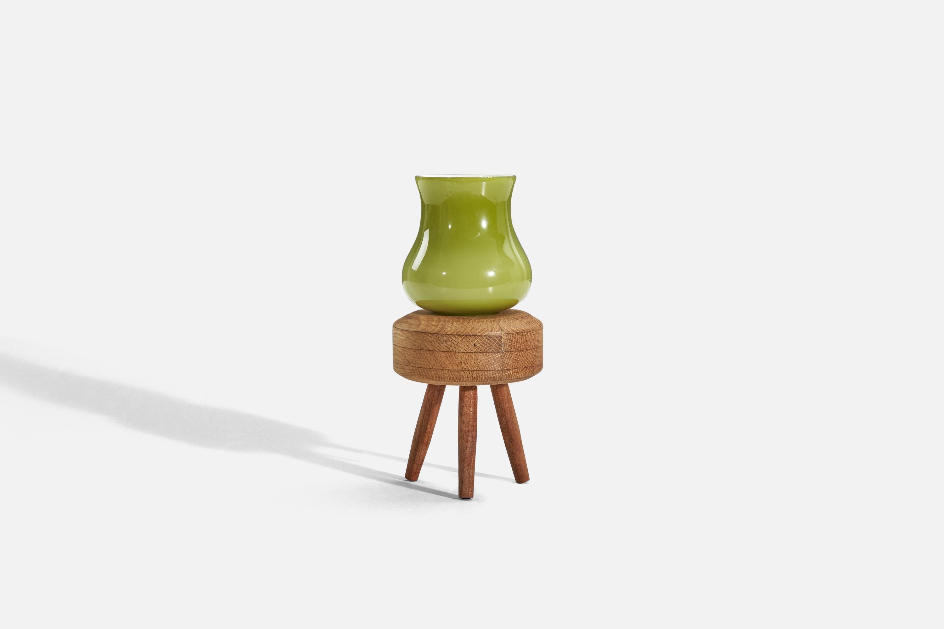 A green glass and oak table lamp, designed and produced in Sweden, c. 1960s. 


