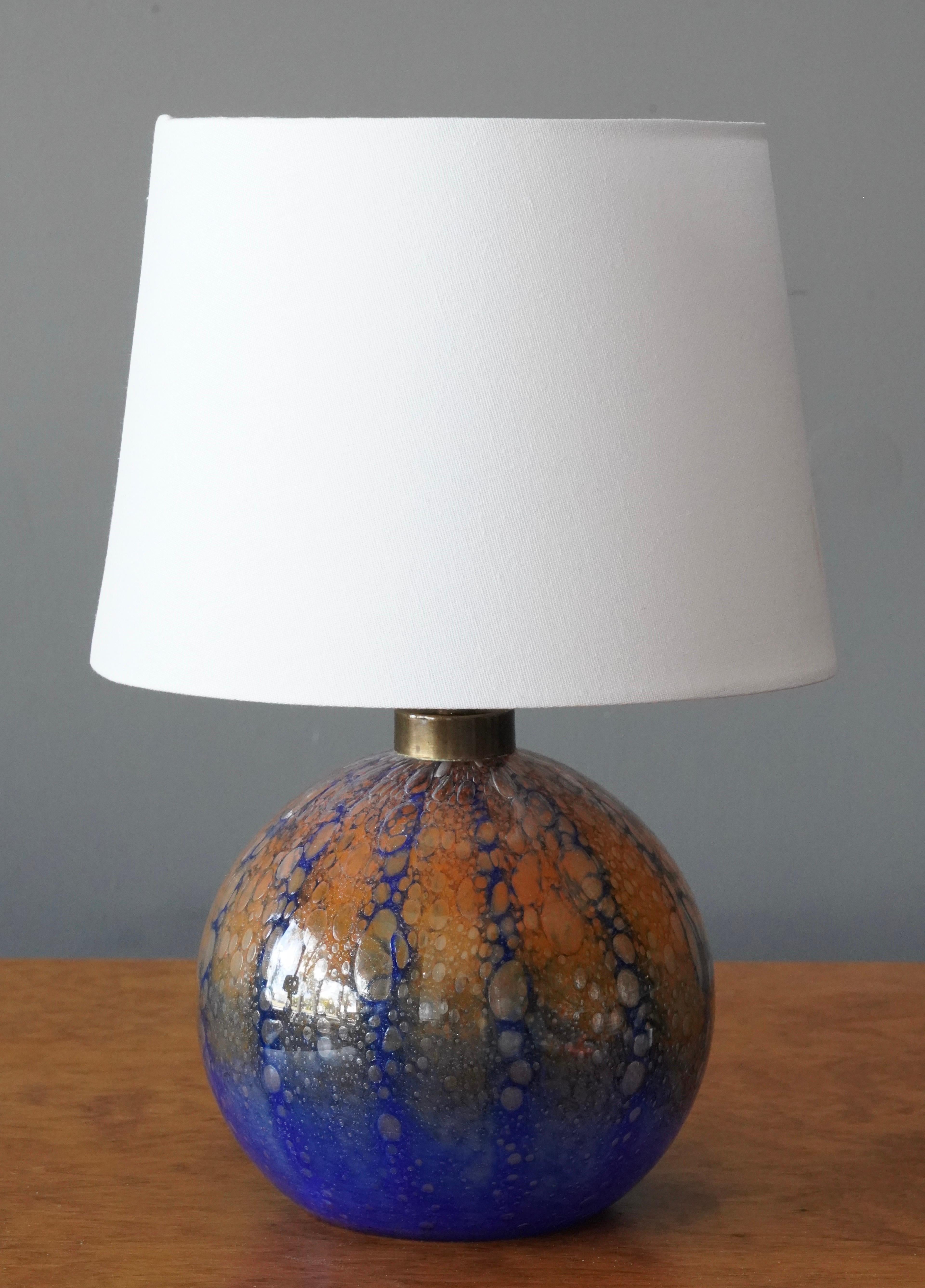 A table lamp in blown blue / orange glass, By a Swedish unknown designer and maker, 1930s.

Lampshade is attached for illustration and not included in purchase. Stated dimensions excluding lampshade. Height includes socket.