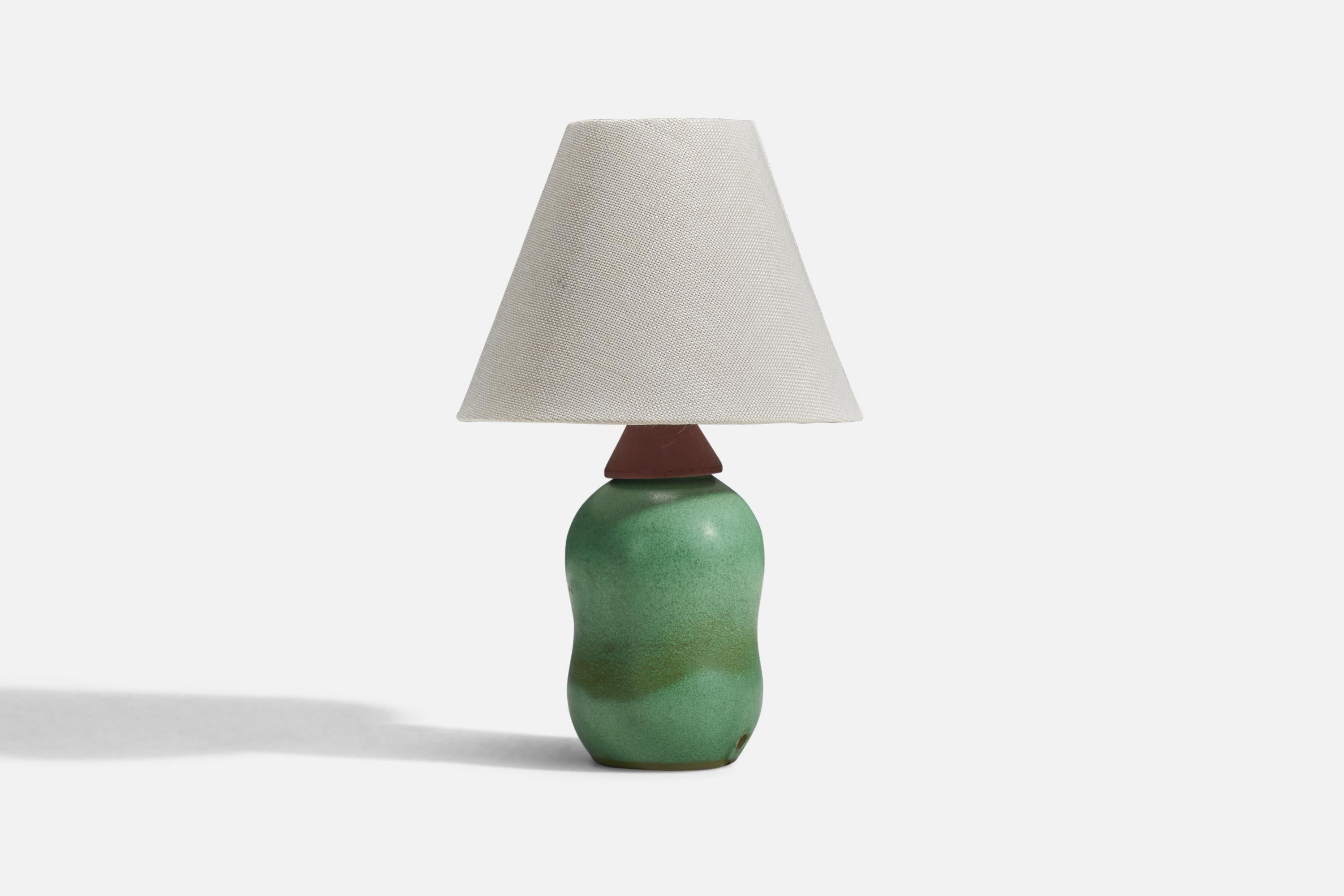 A green glazed stoneware and teak table lamp designed and produced in Sweden, 1950s.

Sold without lampshade
Dimensions of lamp (inches) : 9.62 x 3.93 x 3.93 (Height x Width x Depth)
Dimensions of lampshade (inches) : 3.5 x 8 x 6 (Top Diameter x
