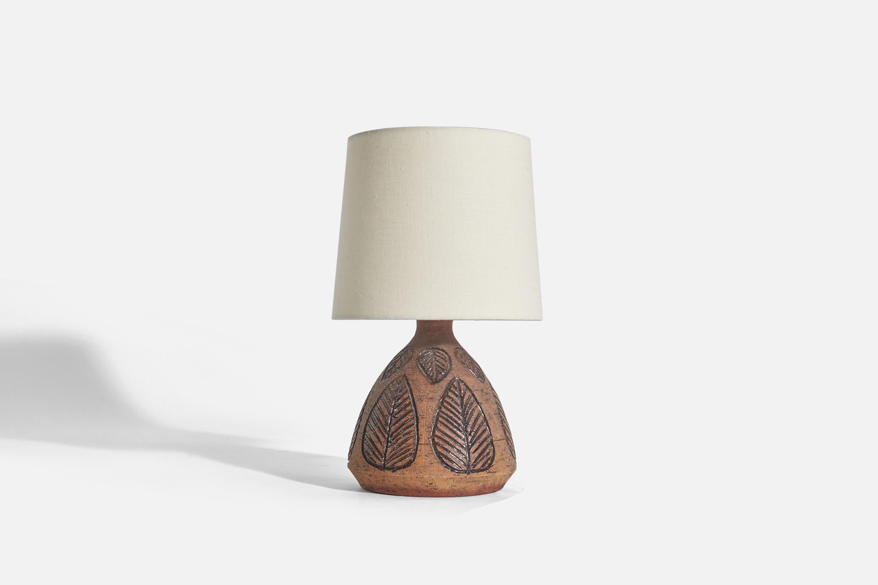 A brown, glazed and incised stoneware table lamp designed and produced in Sweden, c. 1970s.

Sold without Lampshade(s)
Dimensions of Lamp (inches) : 9.18 x 6.43 x 6.43 (Height x Width x Depth)
Dimensions of Shade (inches) : 7 x 8 x 7 (Top Diameter x