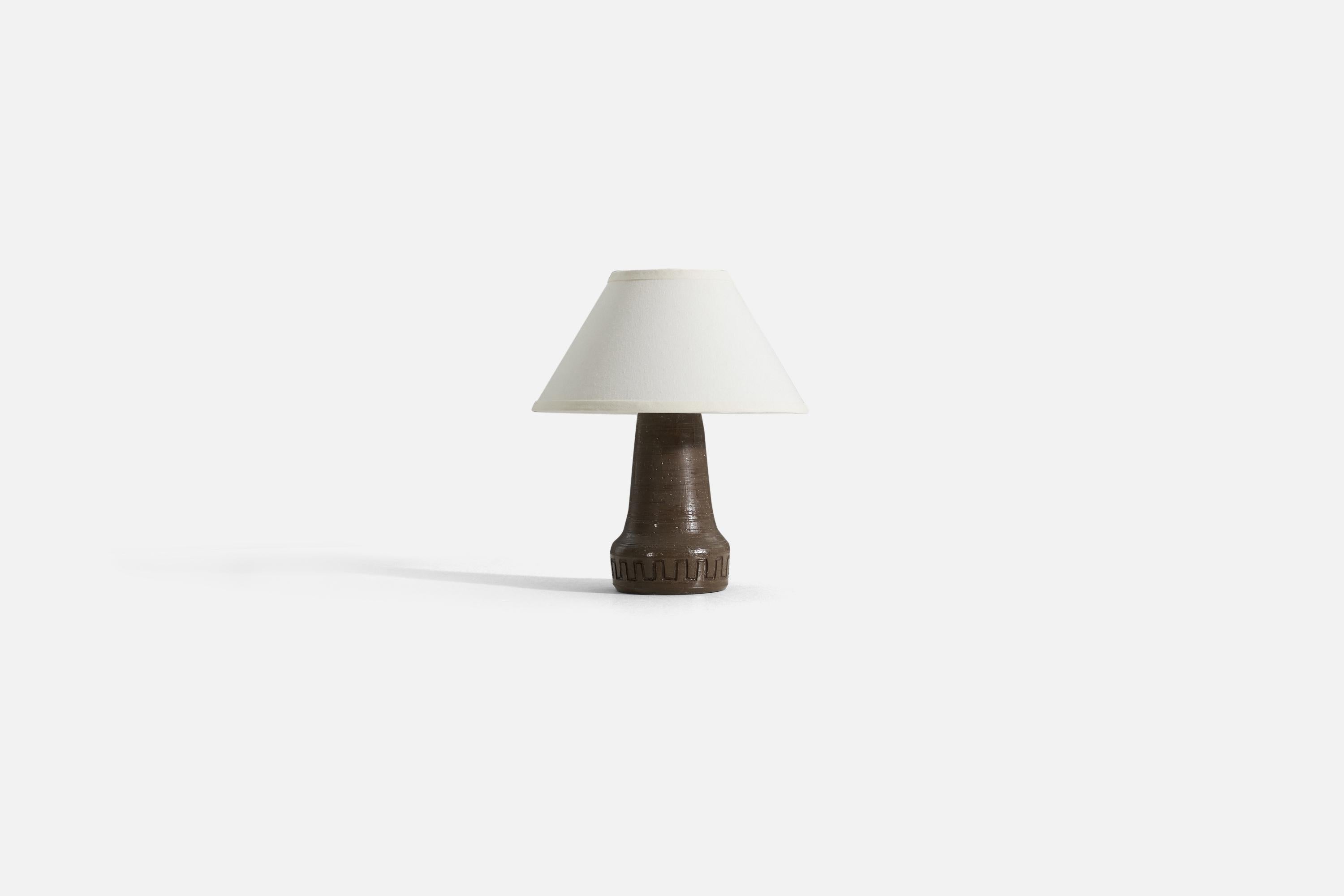 A stoneware table lamp designed and produced in Sweden, 1960s.

Sold without lampshade. 
Dimensions of Lamp (inches) : 11.5 x 5.5 x 5.5 (H x W x D)
Dimensions of Shade (inches) : 5.25 x 12.25 x 7.25 (T x B x H)
Dimension of Lamp with shade