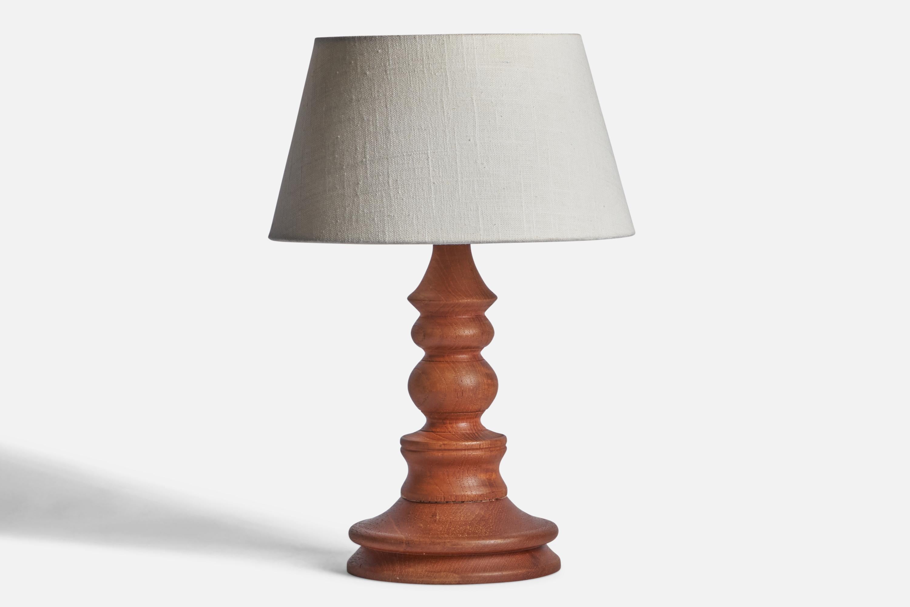 A stained oak table lamp designed and produced in Sweden, 1960s.

Dimensions of Lamp (inches): 11.9” H x 5.85” Diameter
Dimensions of Shade (inches): 7” Top Diameter x 10” Bottom Diameter x 5.5” H 
Dimensions of Lamp with Shade (inches): 15” H x 10”