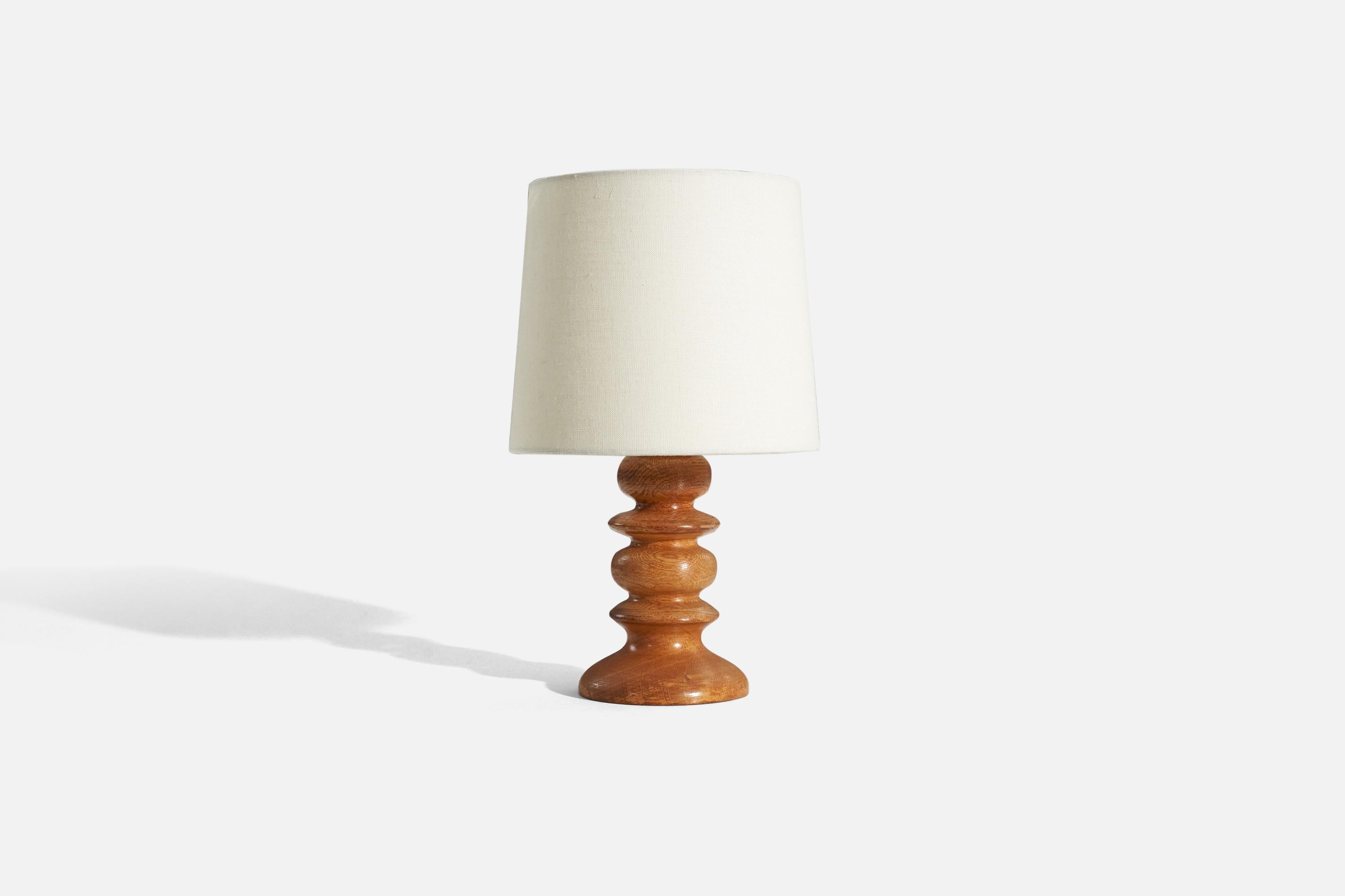 An oak table lamp designed and produced in Sweden, c. 1970s.

Sold without lampshade. 
Dimensions of Lamp (inches) : 9.25 x 4.5 x 4.5 (H x W x D)
Dimensions of Shade (inches) : 7 x 8 x 7 (T x B x H)
Dimension of Lamp with Shade (inches) : 13.4375 x