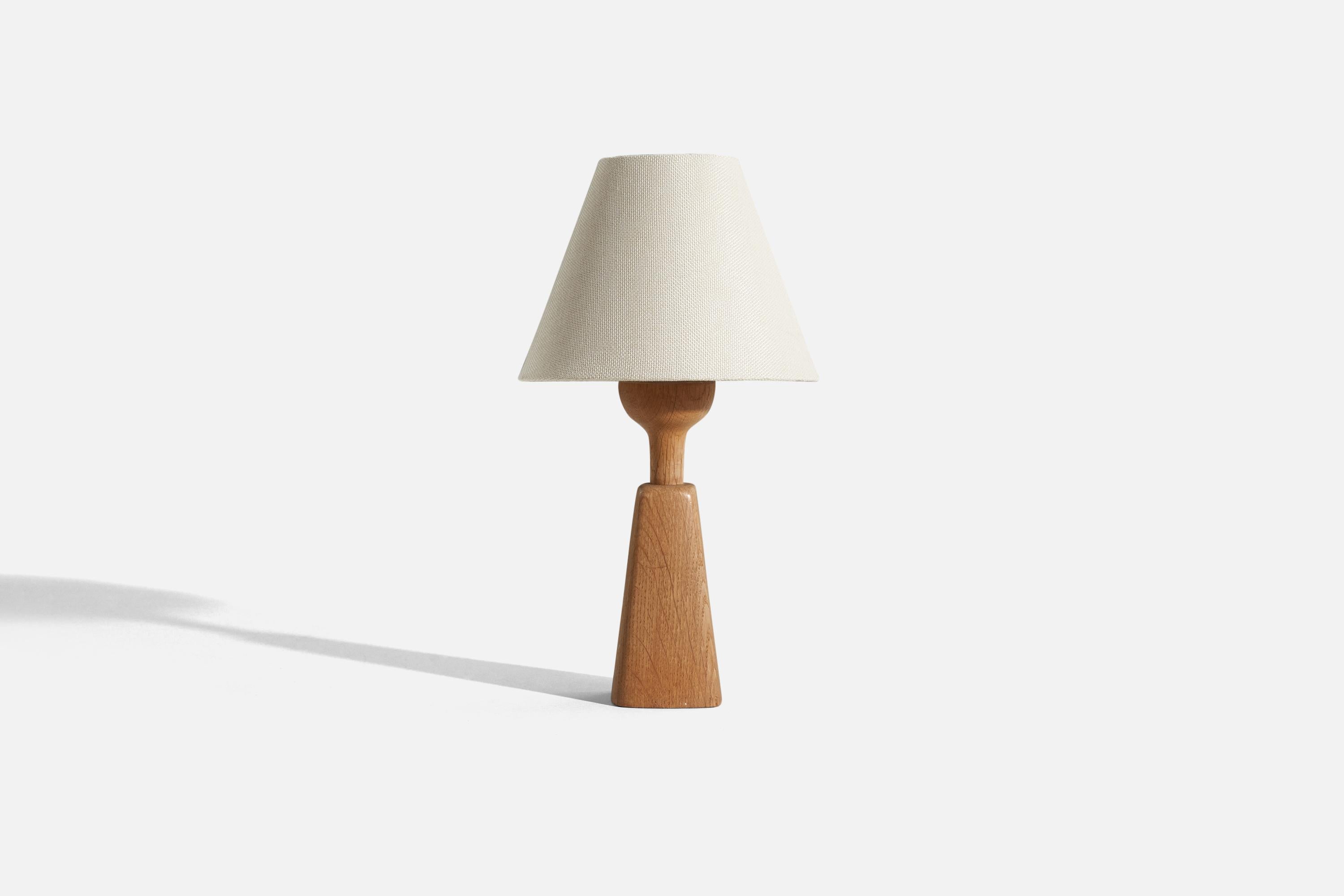 An oak table lamp designed and produced in Sweden, c. 1970s.

Sold without lampshade. 
Dimensions of Lamp (inches) : 10.625 x 3 x 3 (H x W x D)
Dimensions of Shade (inches) : 3.75 x 8 x 6.25 (T x B x H)
Dimension of Lamp with Shade (inches) : 14.25